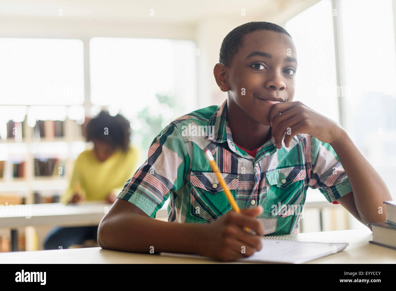 Black student thinking in classroom Stock Photo