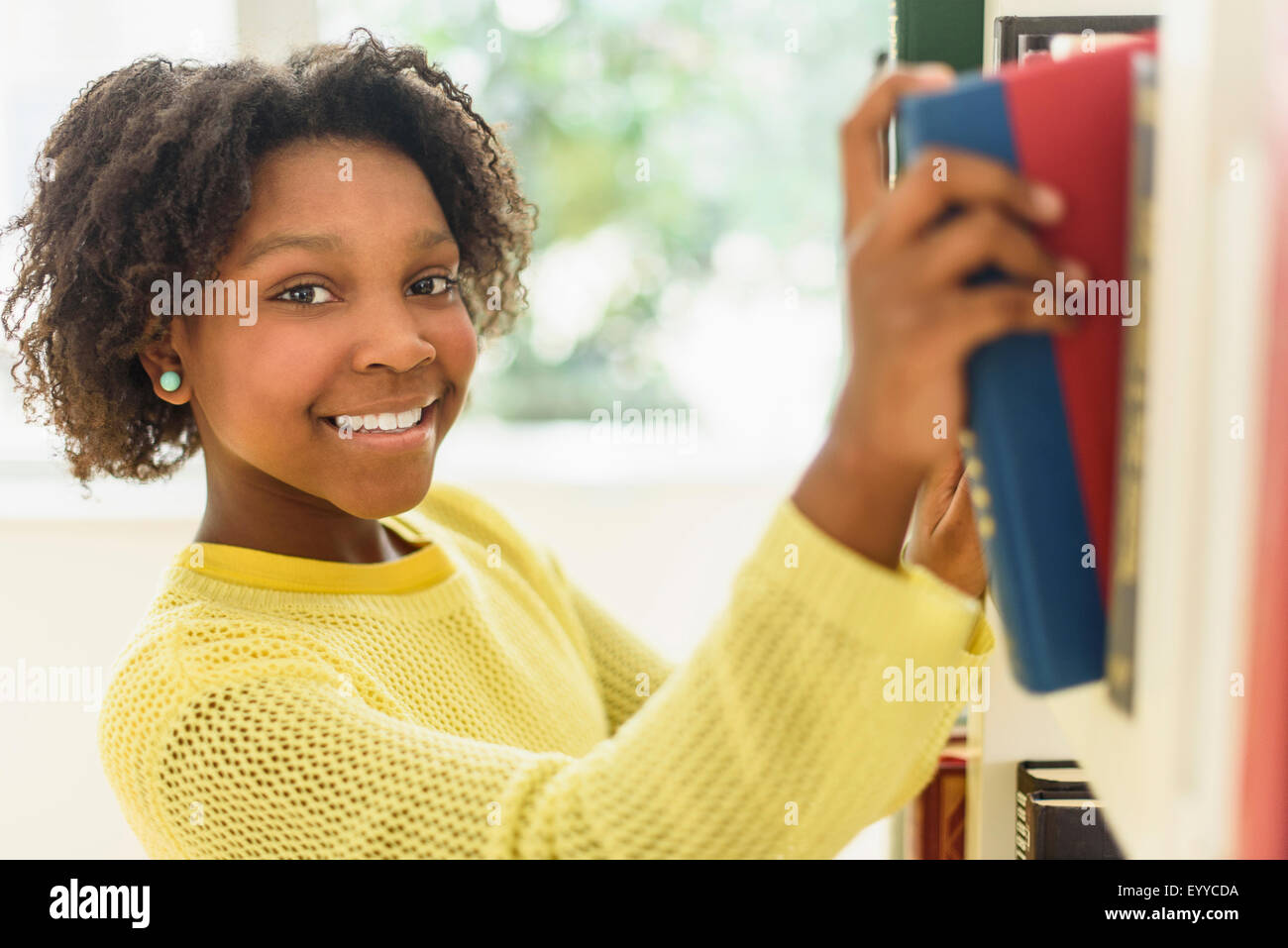 Black student choosing book from library shelf Stock Photo