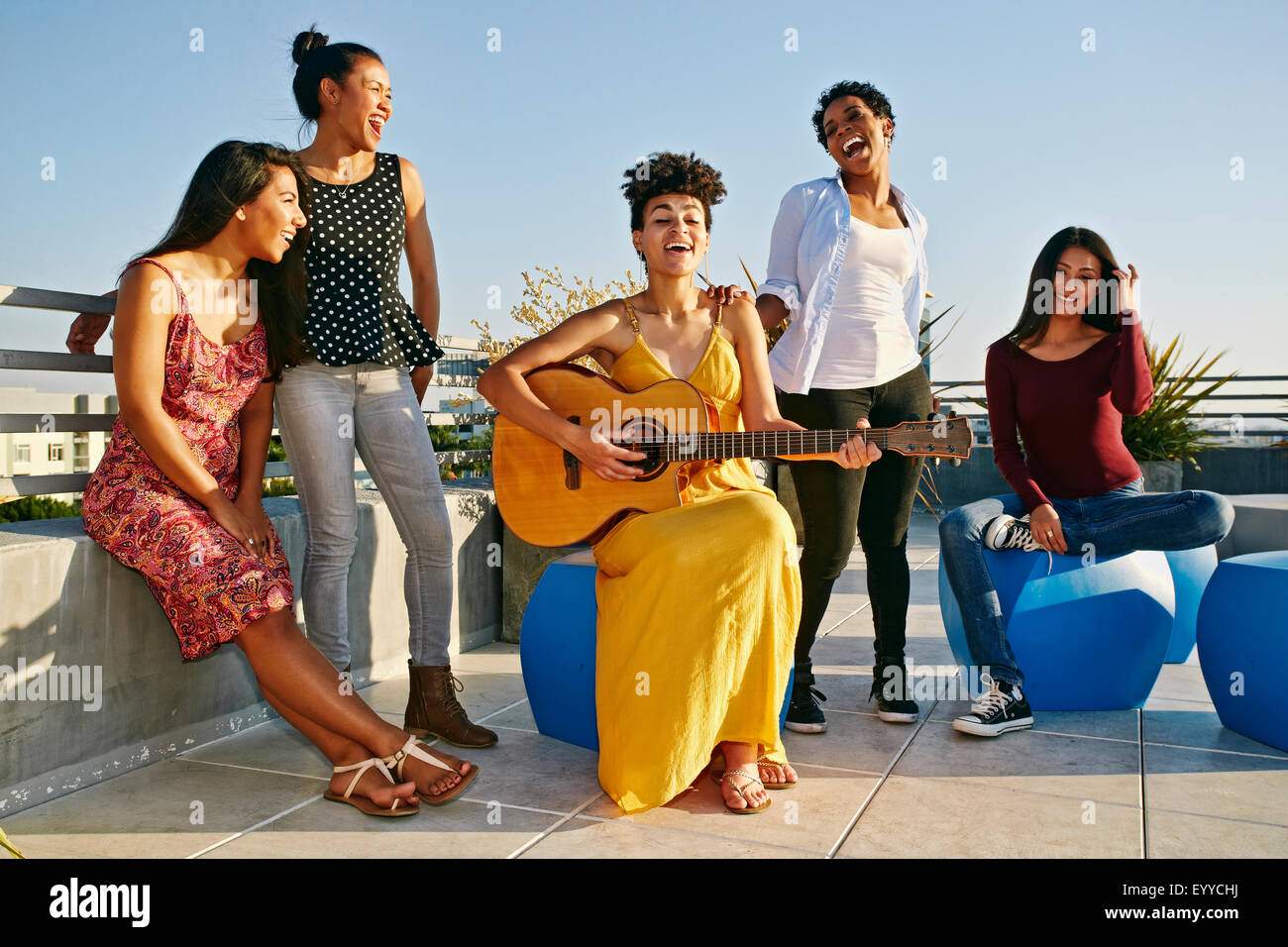 Women playing music and singing on urban rooftop Stock Photo
