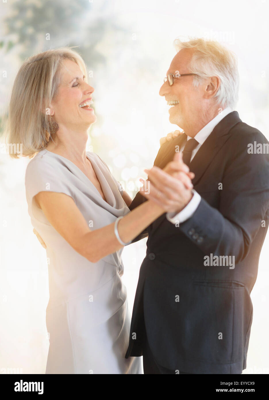 Smiling older Caucasian couple dancing Stock Photo