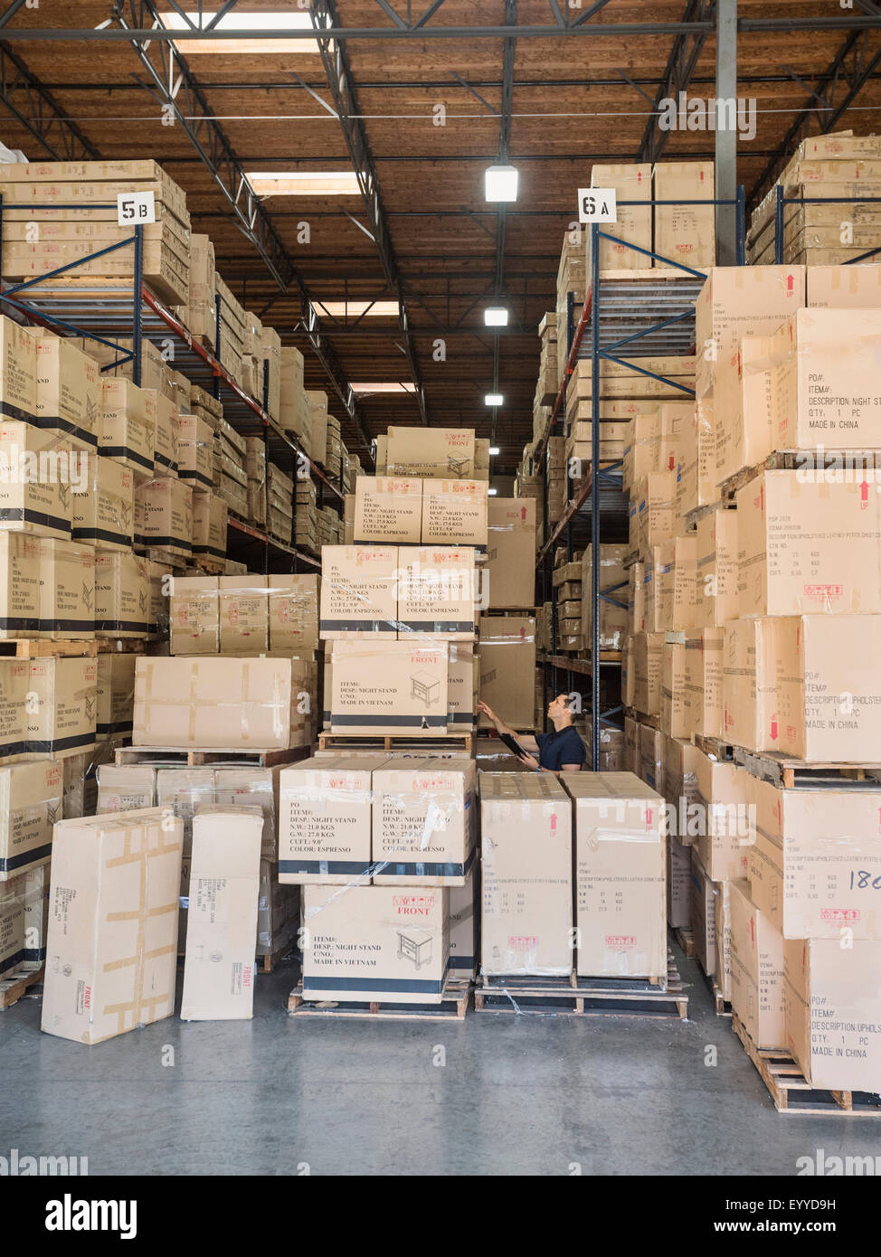 Caucasian worker examining cardboard boxes in warehouse Stock Photo Alamy