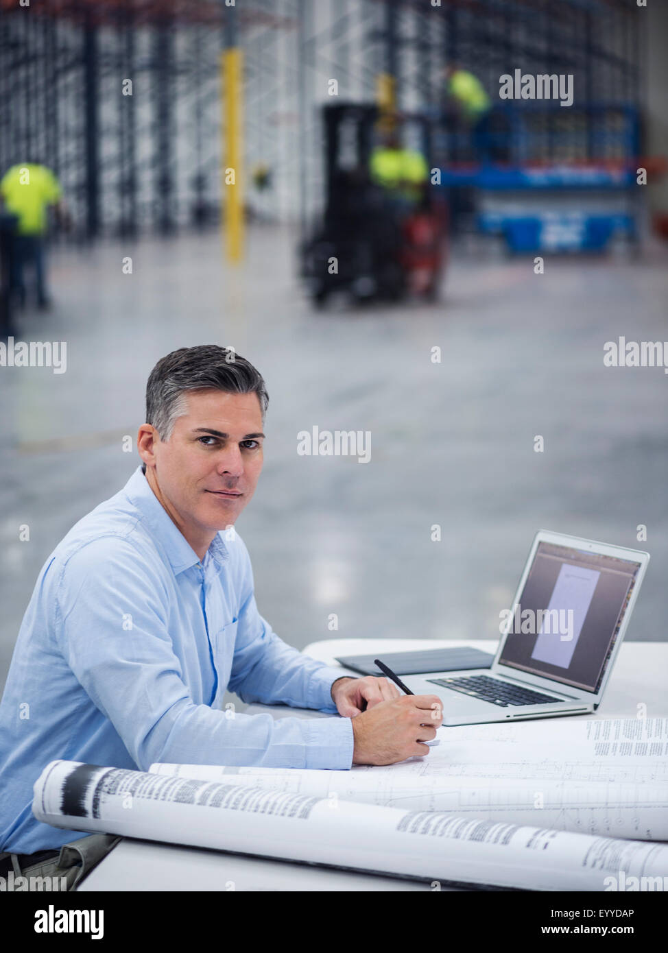 Caucasian architect working in warehouse Stock Photo Alamy