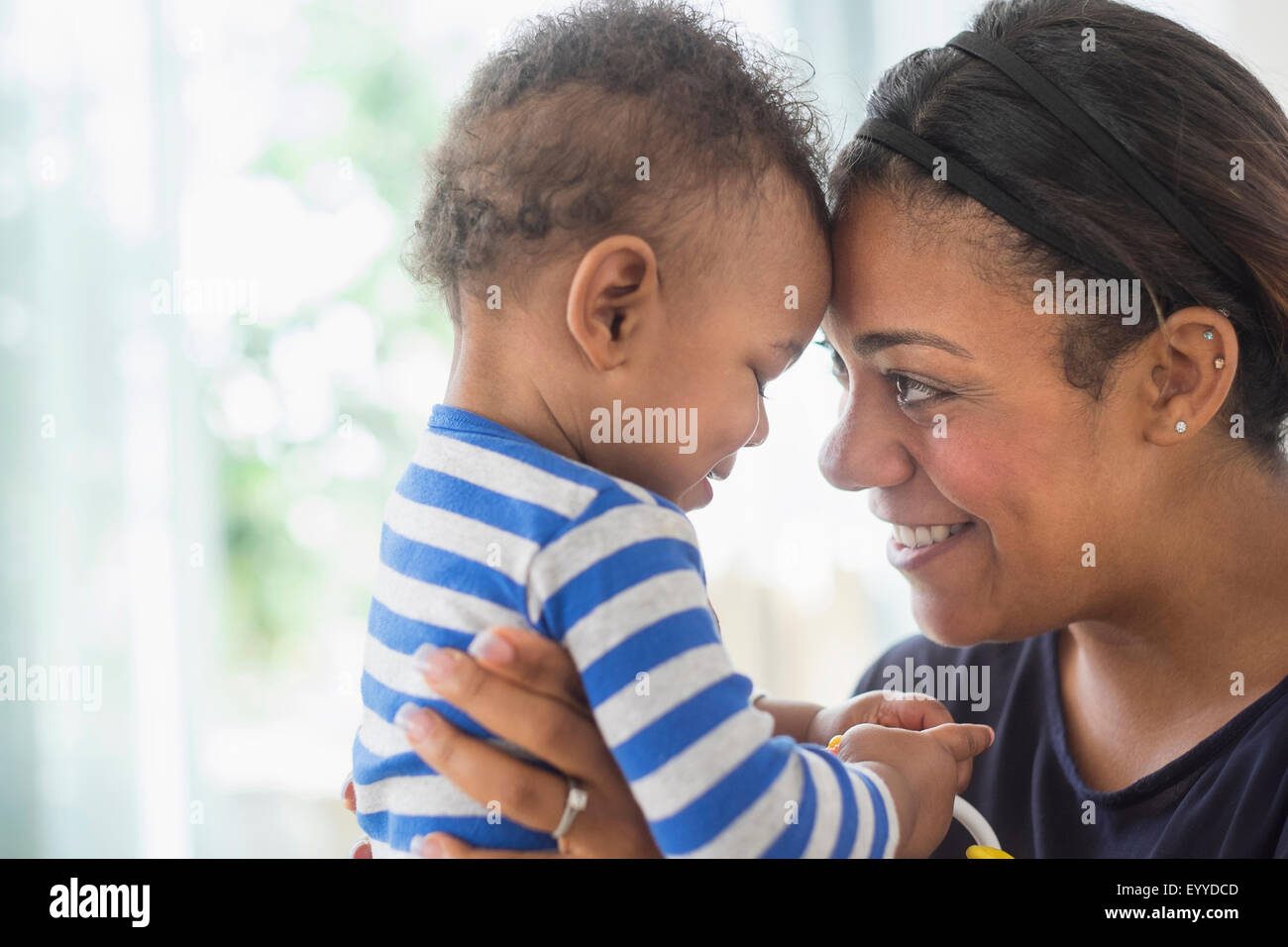 Close up of mixed race mother holding baby son Stock Photo