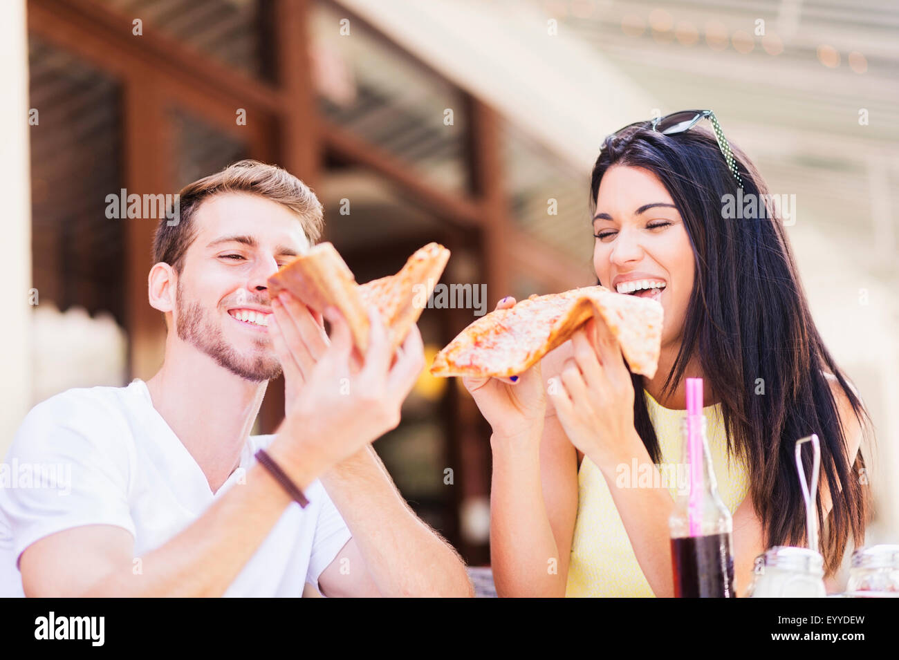 Hispanic couple eating pizza at cafe Stock Photo