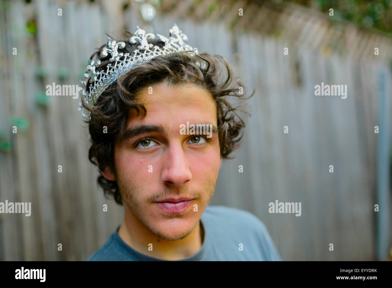 Hispanic man wearing crown in backyard Stock Photo