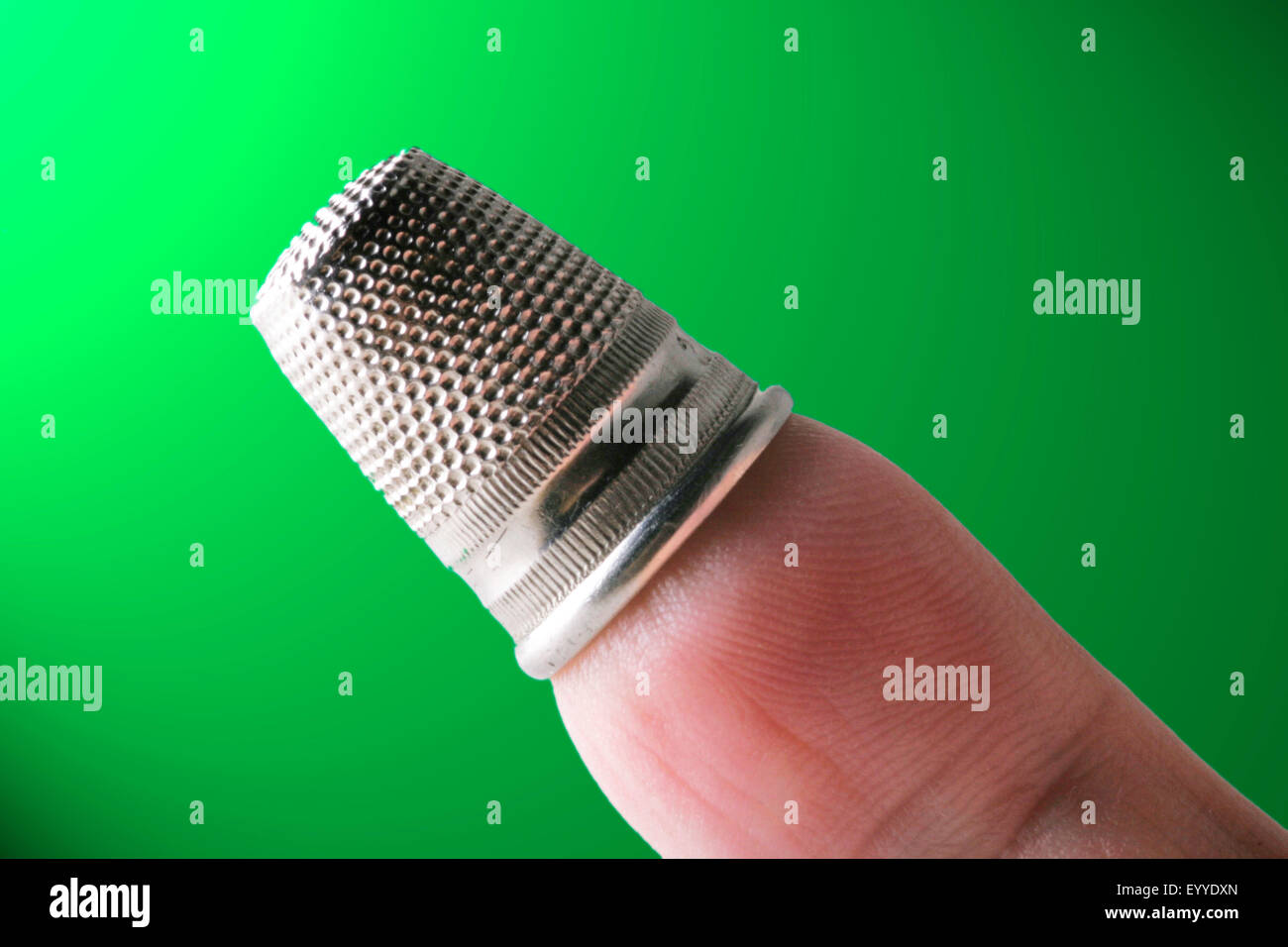 silvery thimble on a finger Stock Photo