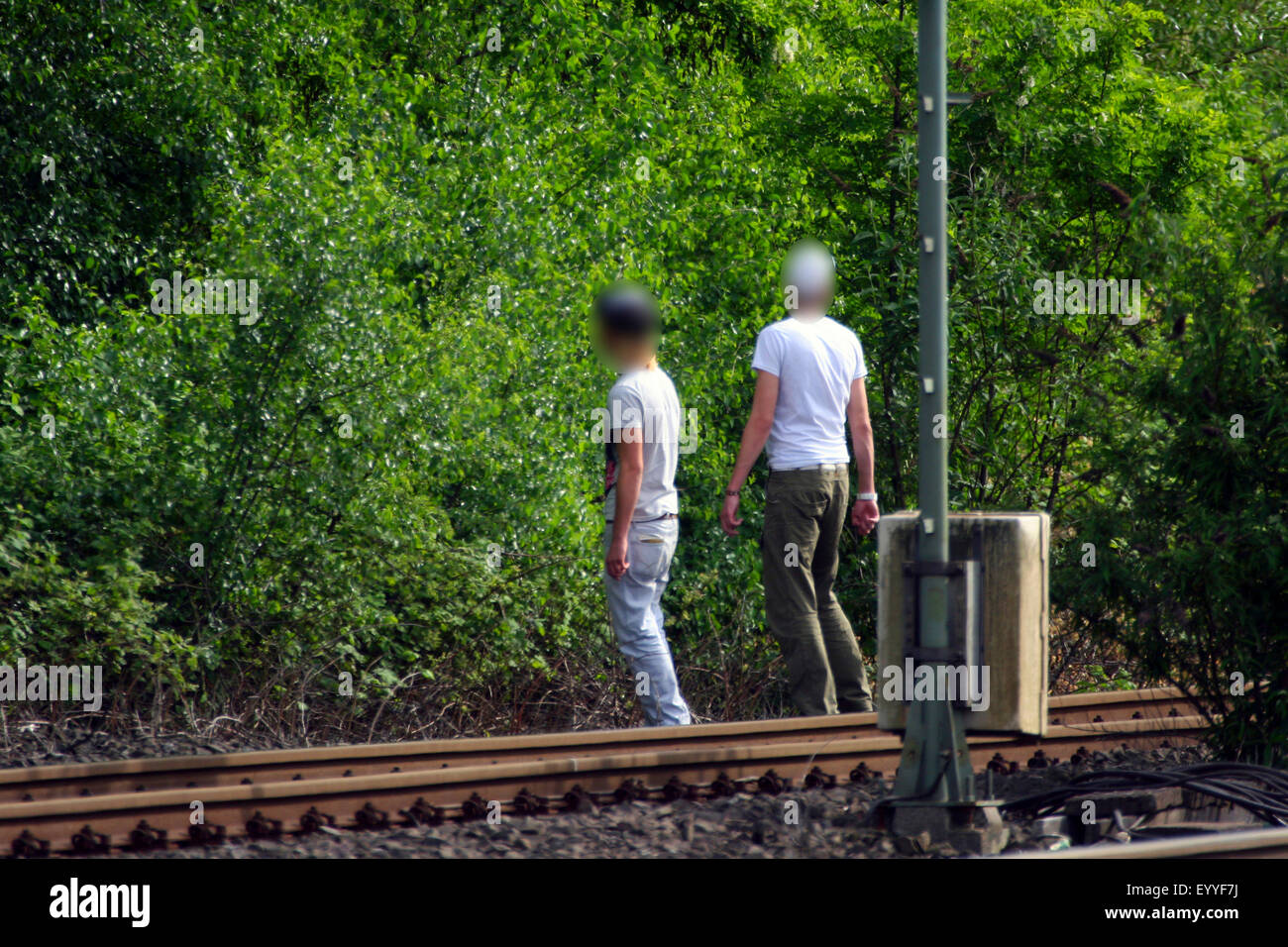 two persons crossing railtracks, Germany Stock Photo