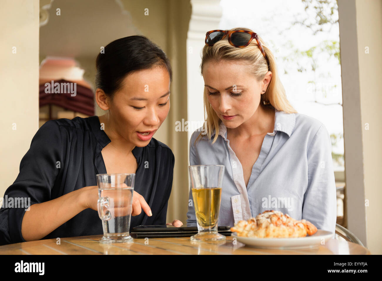 Businesswomen using digital tablet in cafe Stock Photo - Alamy