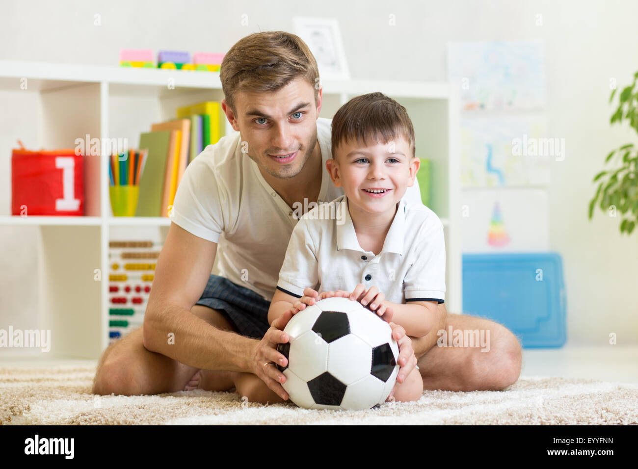 child boy with dad play foot ball at home Stock Photo