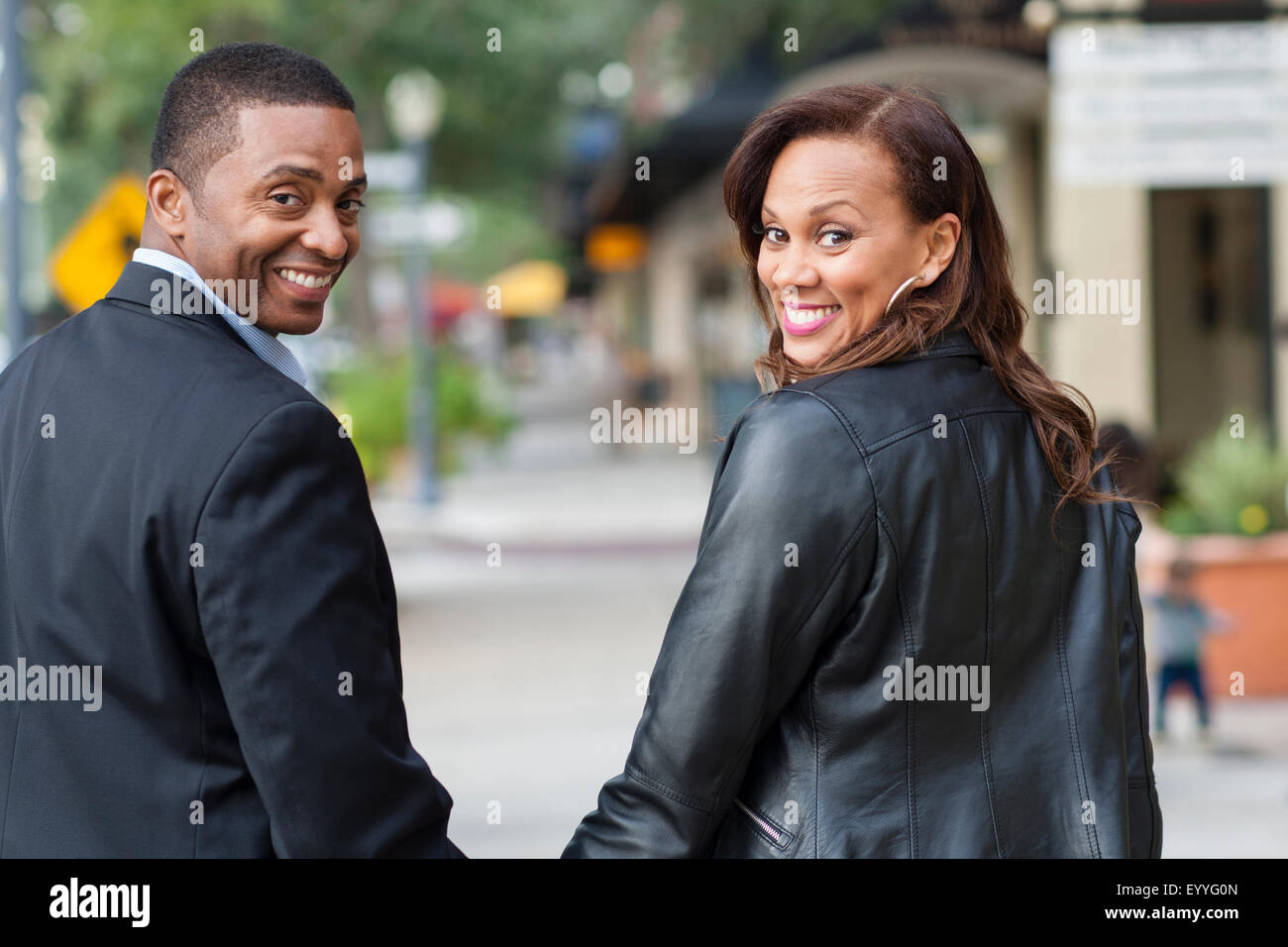 Couple looking over shoulders in city Stock Photo