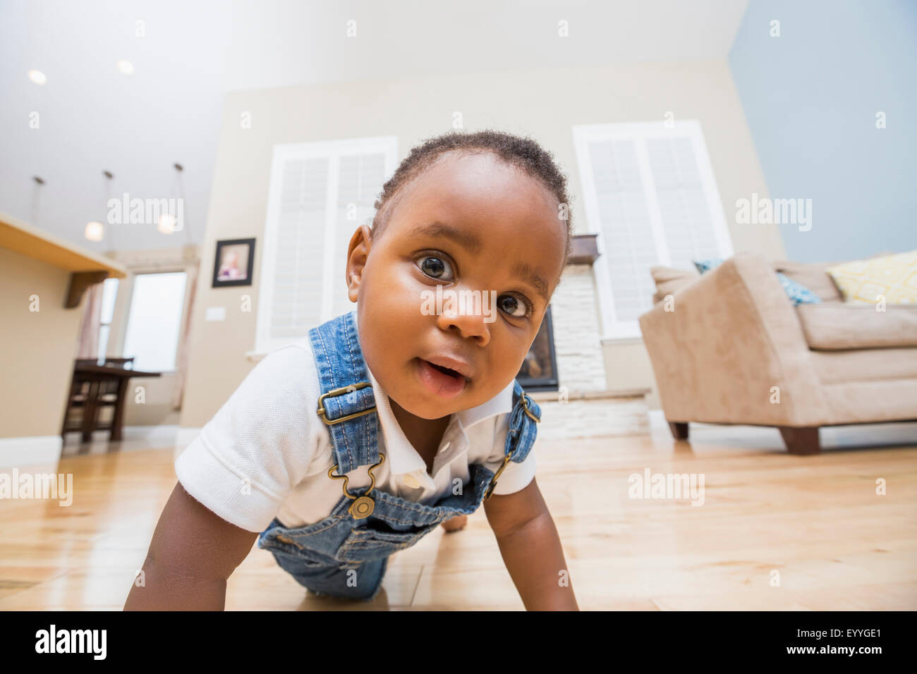 Black baby crawling on living room floor Stock Photo