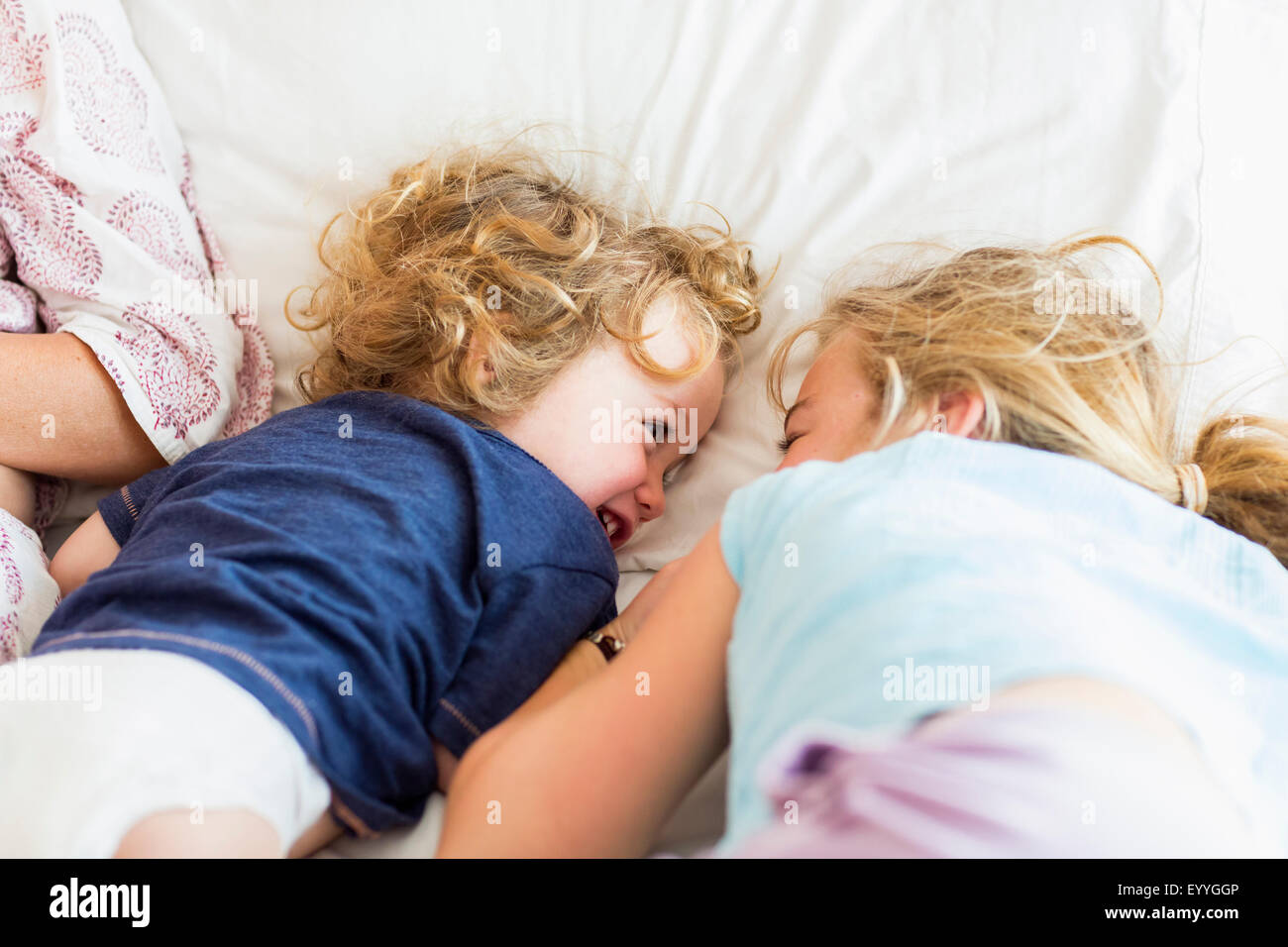 Caucasian brother and sister playing on bed Stock Photo