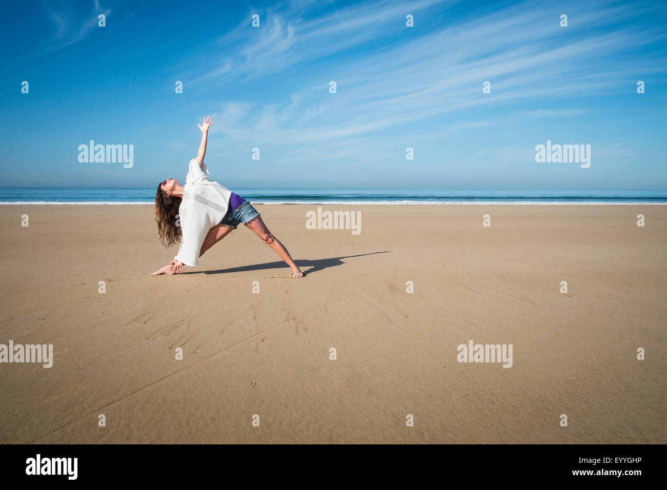 Caucasian woman practicing yoga on beach Stock Photo