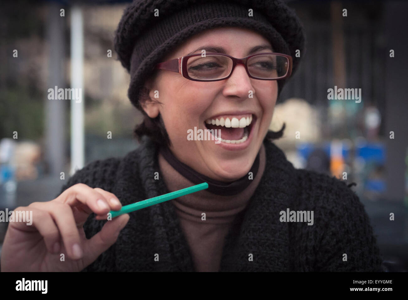 Close up of laughing Caucasian woman holding pencil Stock Photo