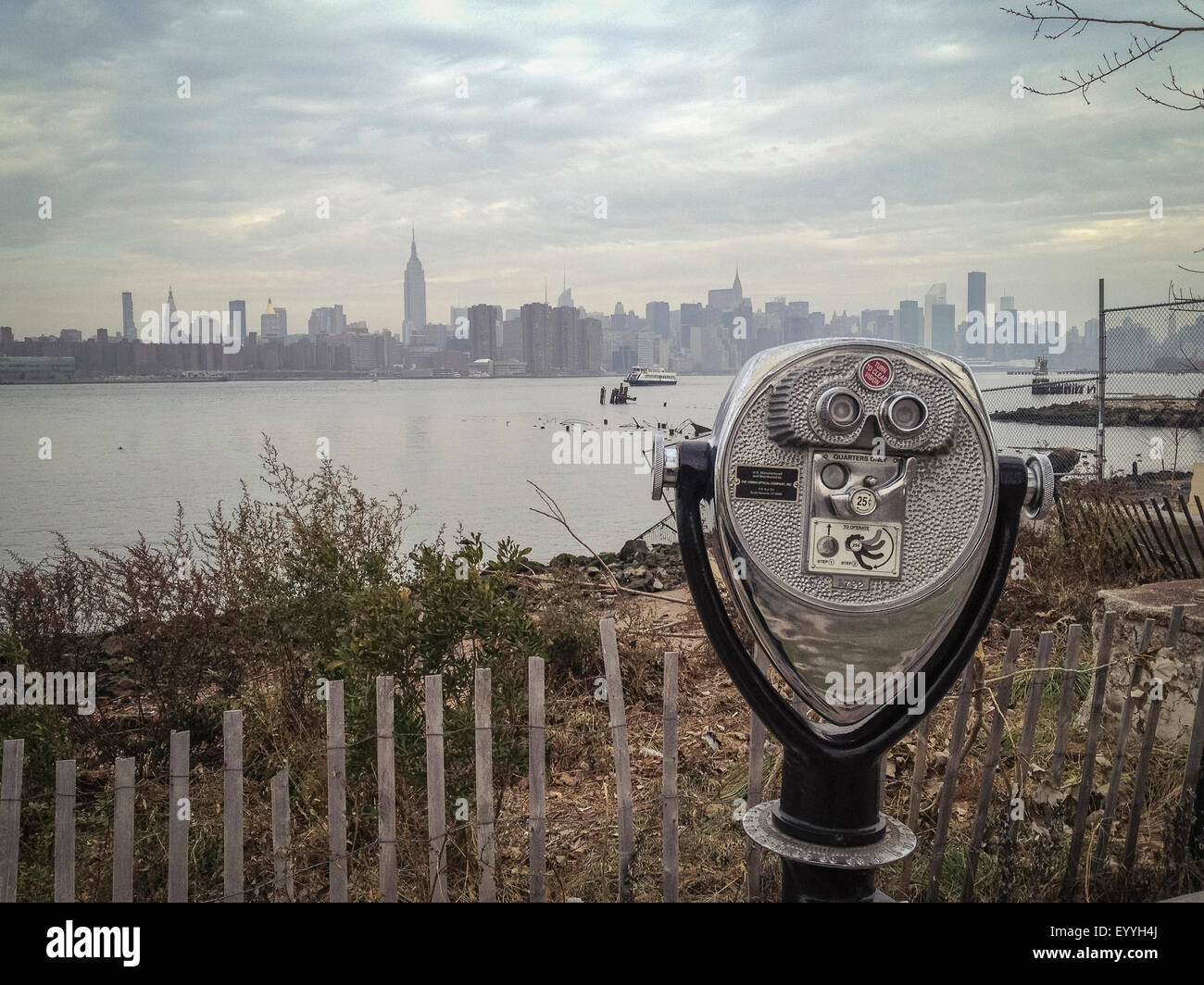 Coin-operated binoculars viewing city skyline on urban waterfront Stock Photo