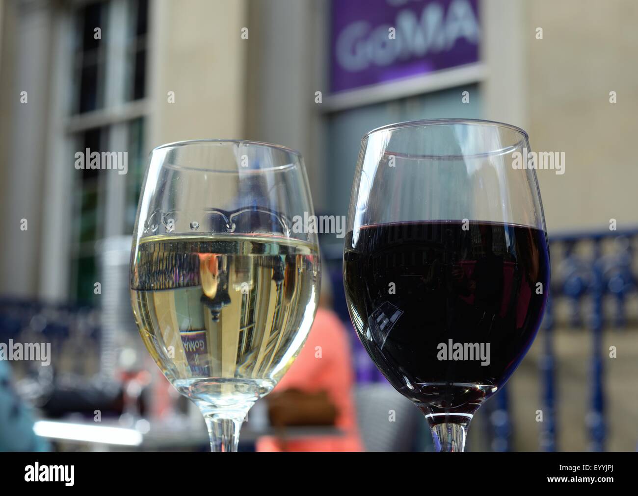 Glass of red wine and glass of white wine on outdoor table of a city centre bar, Glasgow Stock Photo