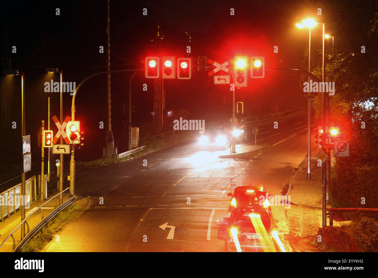 crossing with traffic signs and railroad crossing the evening, Germany, North Rhine-Westphalia Stock Photo