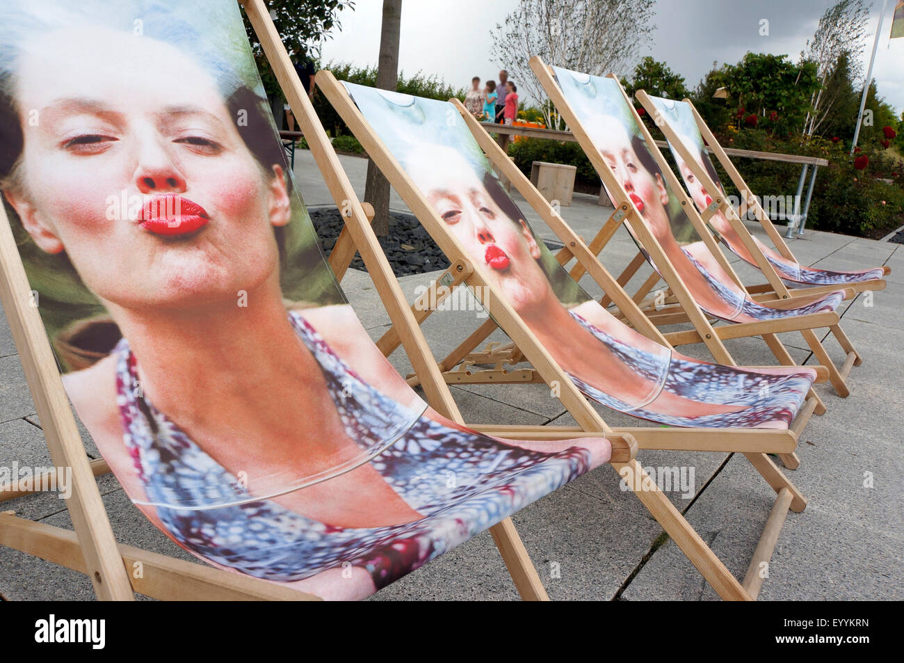 women with puckered lips as cover on canvas chairs, Germany Stock Photo