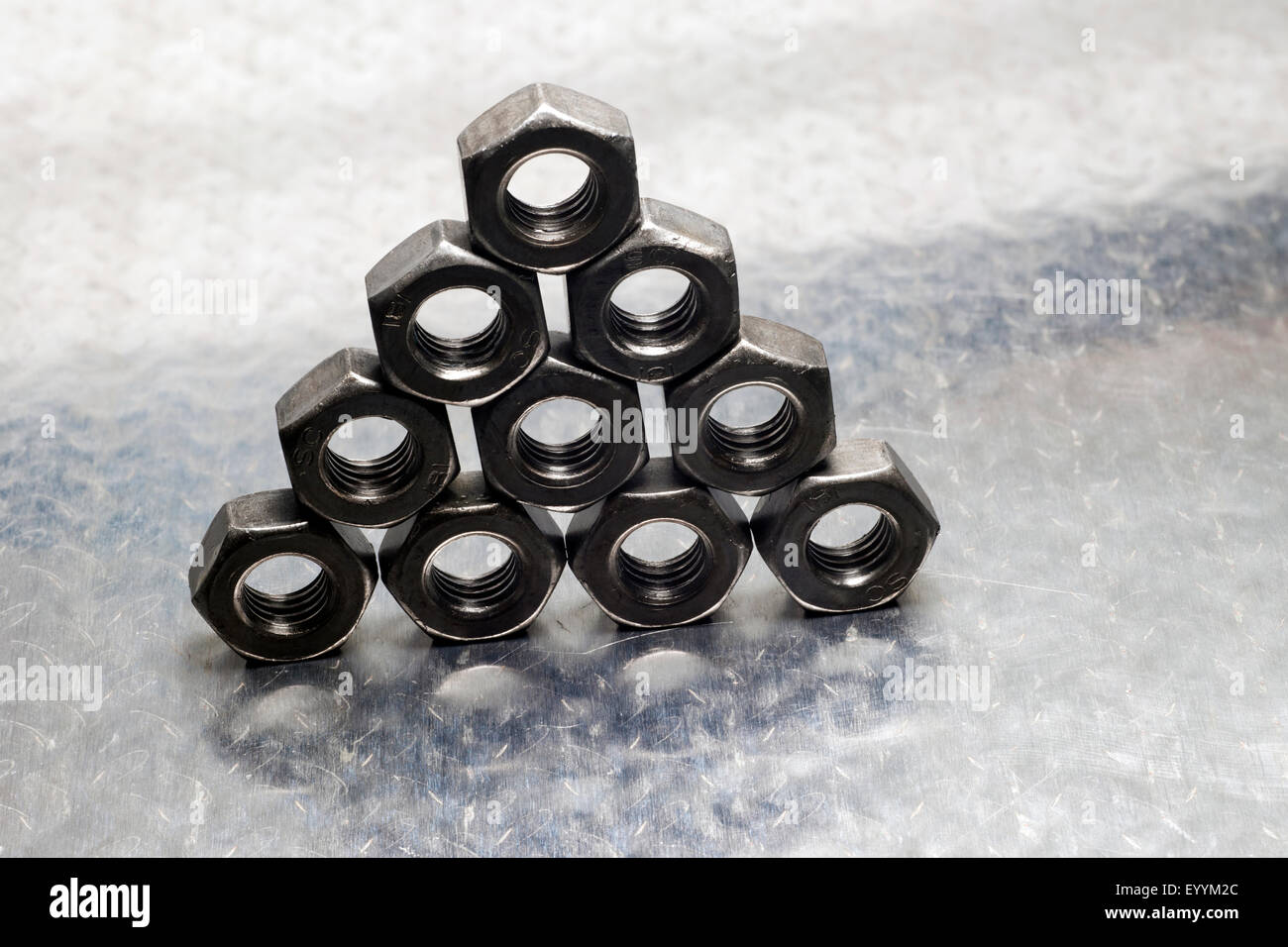 Steel metric nuts formed into a pyramid shape. Stock Photo