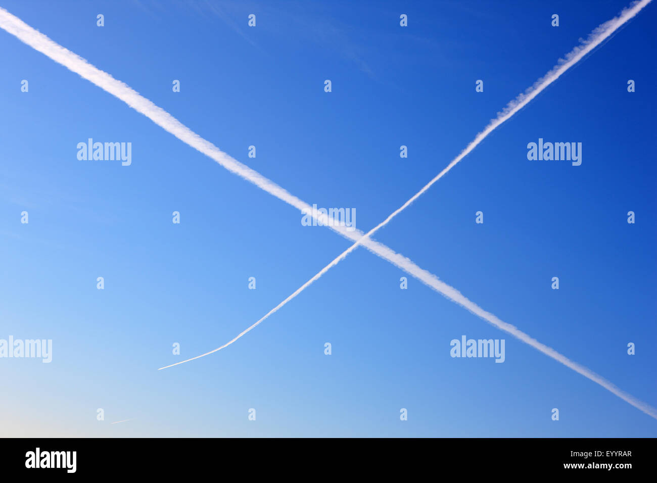 Blue sky and plane trails forming a cross like Scotlands saltire flag Stock Photo