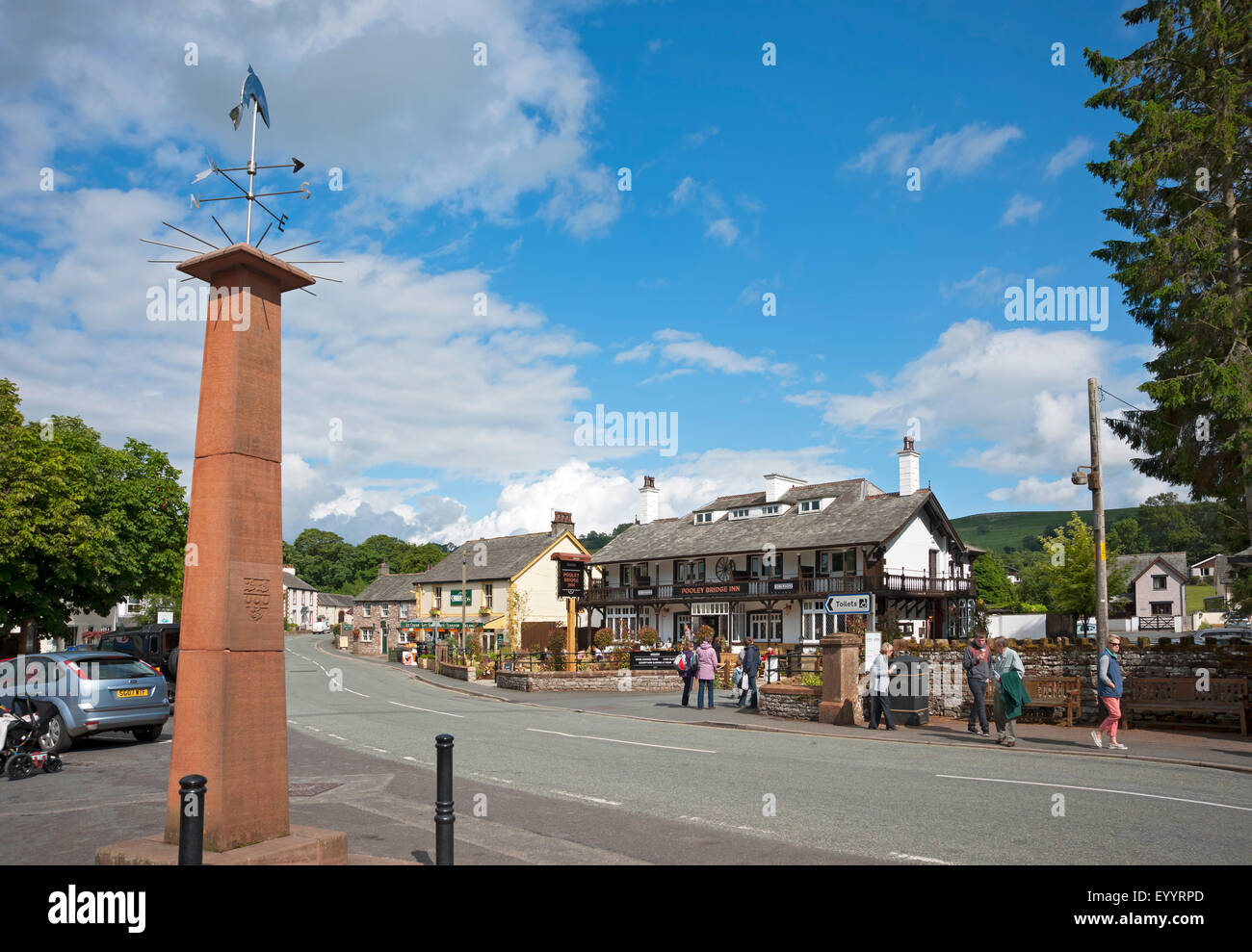 Looking along the main street Pooley Bridge village near Ullswater in summer Cumbria England UK