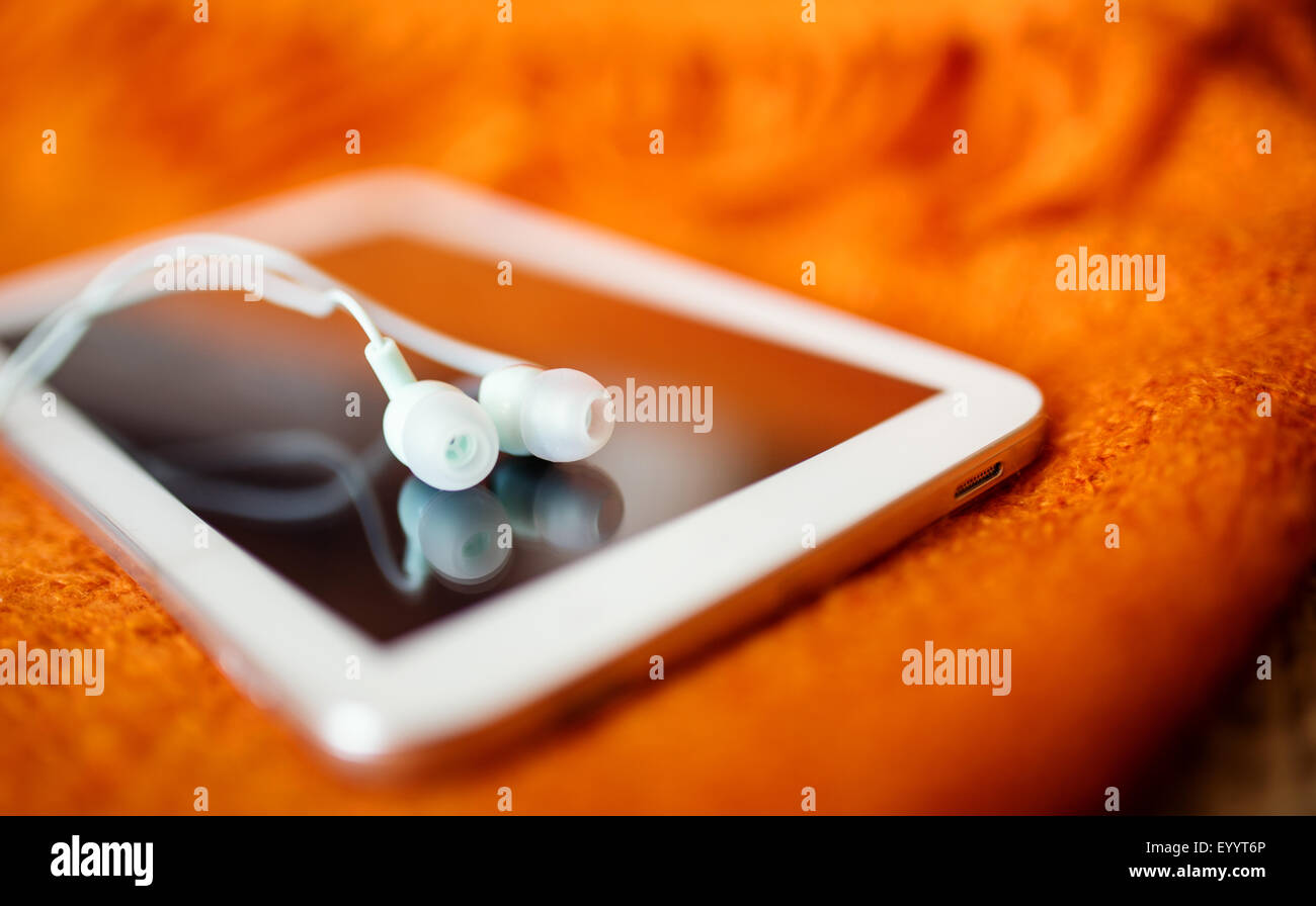 White earphones and tablet pc, close up photo, small dof Stock Photo