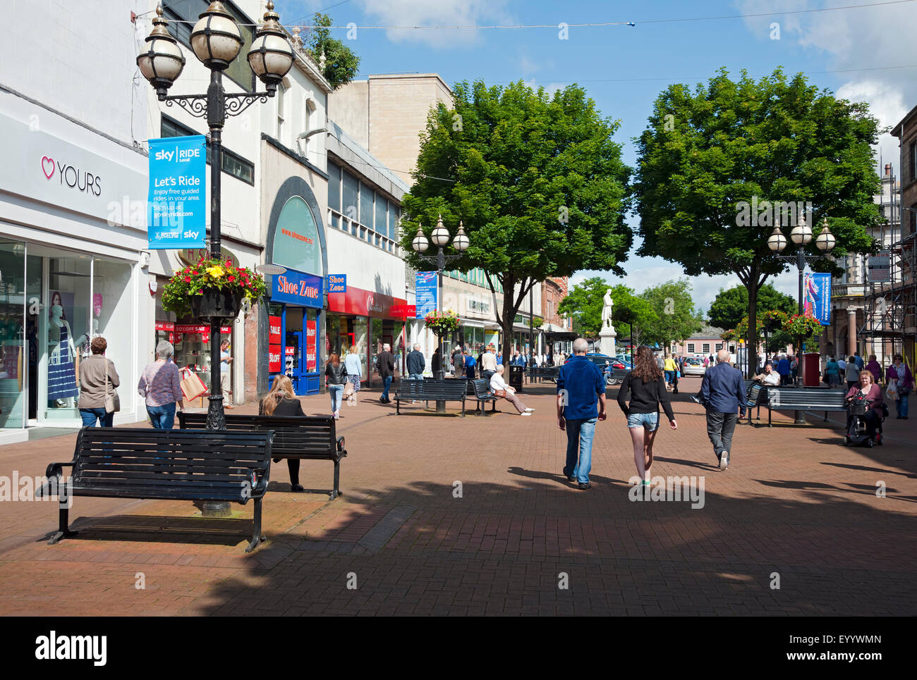 People visitors tourists walking around the shops shopping stores town centre in summer Carlisle Cumbria England UK United Kingdom GB Great Britain Stock Photo