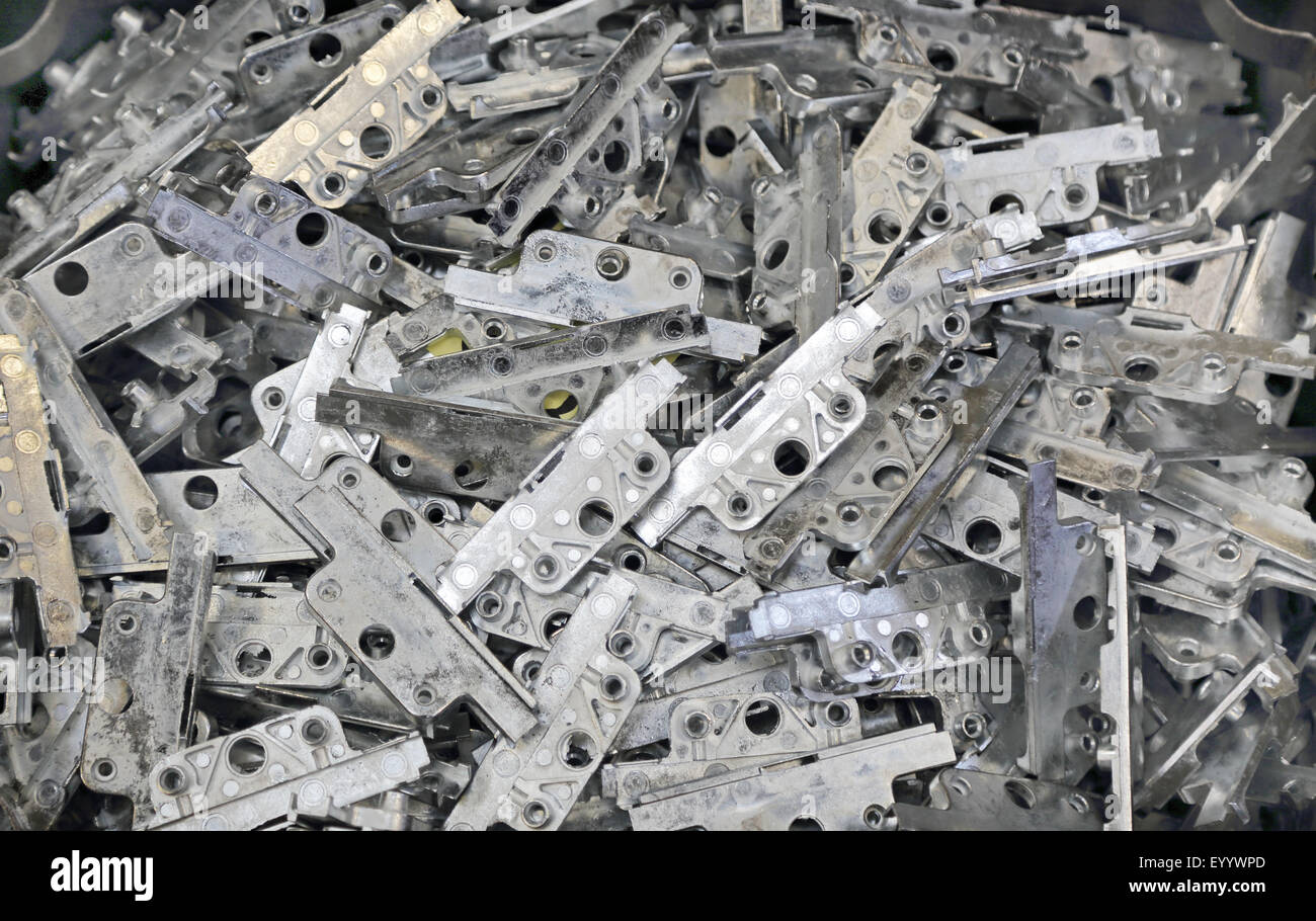 pressed steel window hinge and lock components lay loose in a container during manufacture and fabrication Stock Photo
