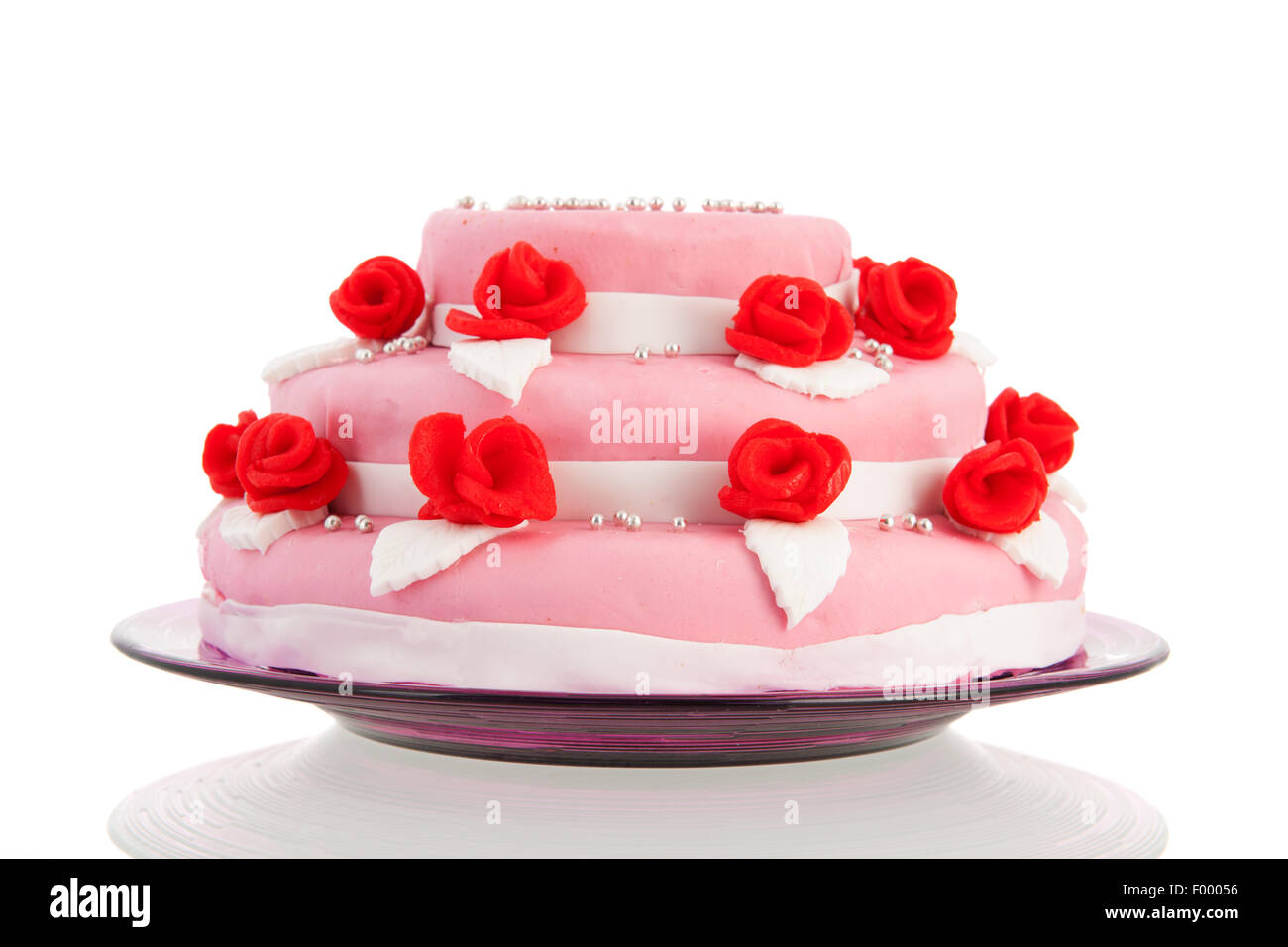 Pink wedding cake with red roses isolated over white background Stock