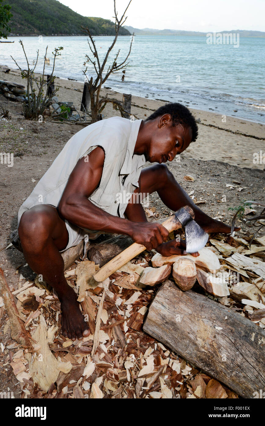 native man of Madagascar carves a wooden sculpture for souvenir, Madagascar, Nosy Be, Lokobe Reserva Stock Photo