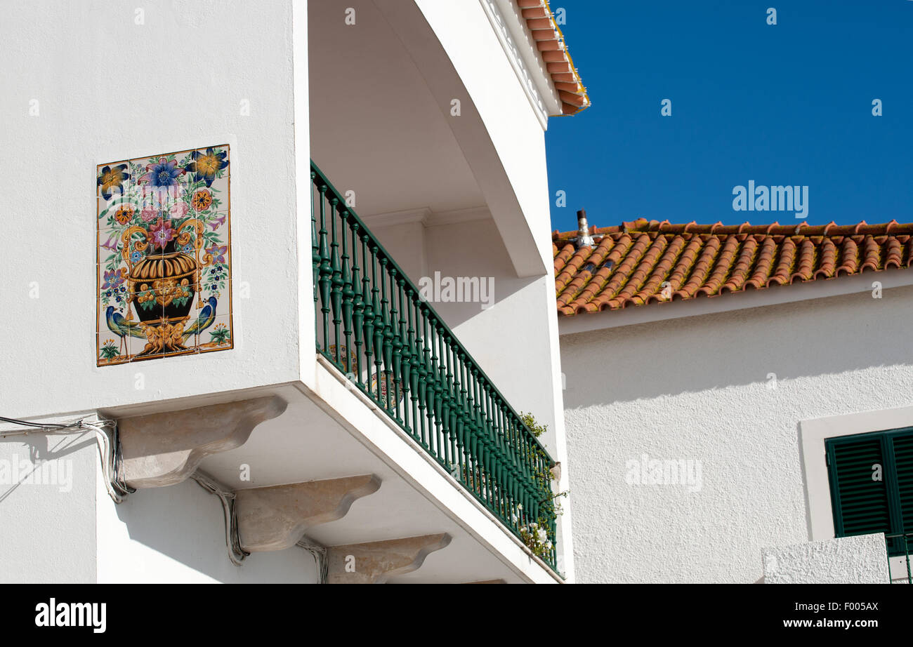 Home with Ceramic glazed tile picture plaque on the wall and balcony in Nazare , Portugal Stock Photo