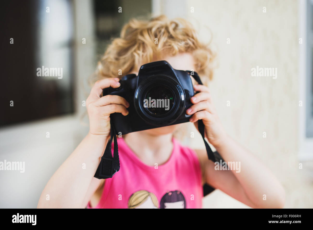 Little girl taking picture with SLR camera Stock Photo