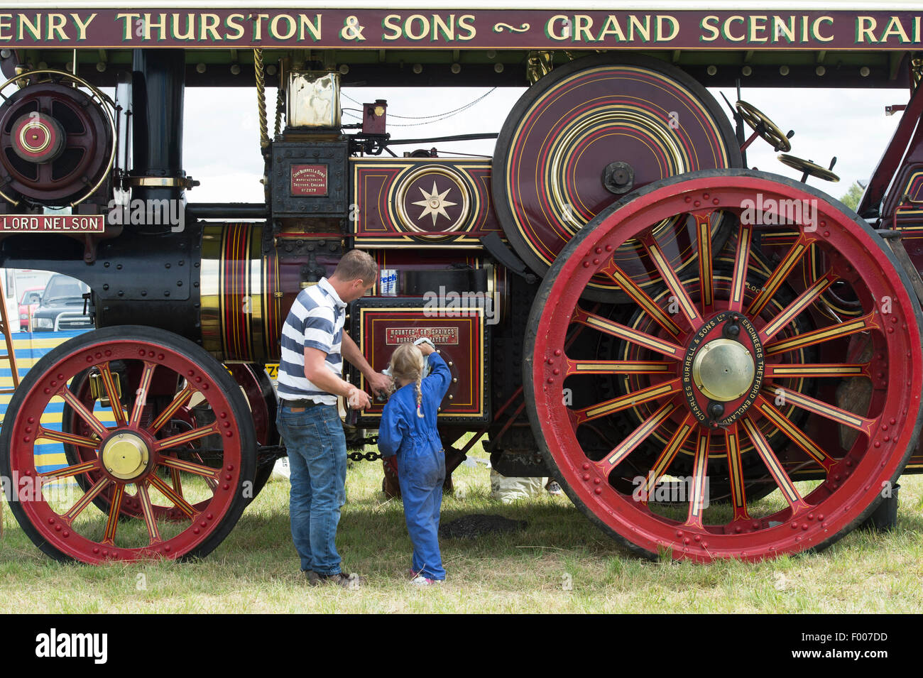 Man and girl cleaning a showmans traction engine at a steam fair in England Stock Photo