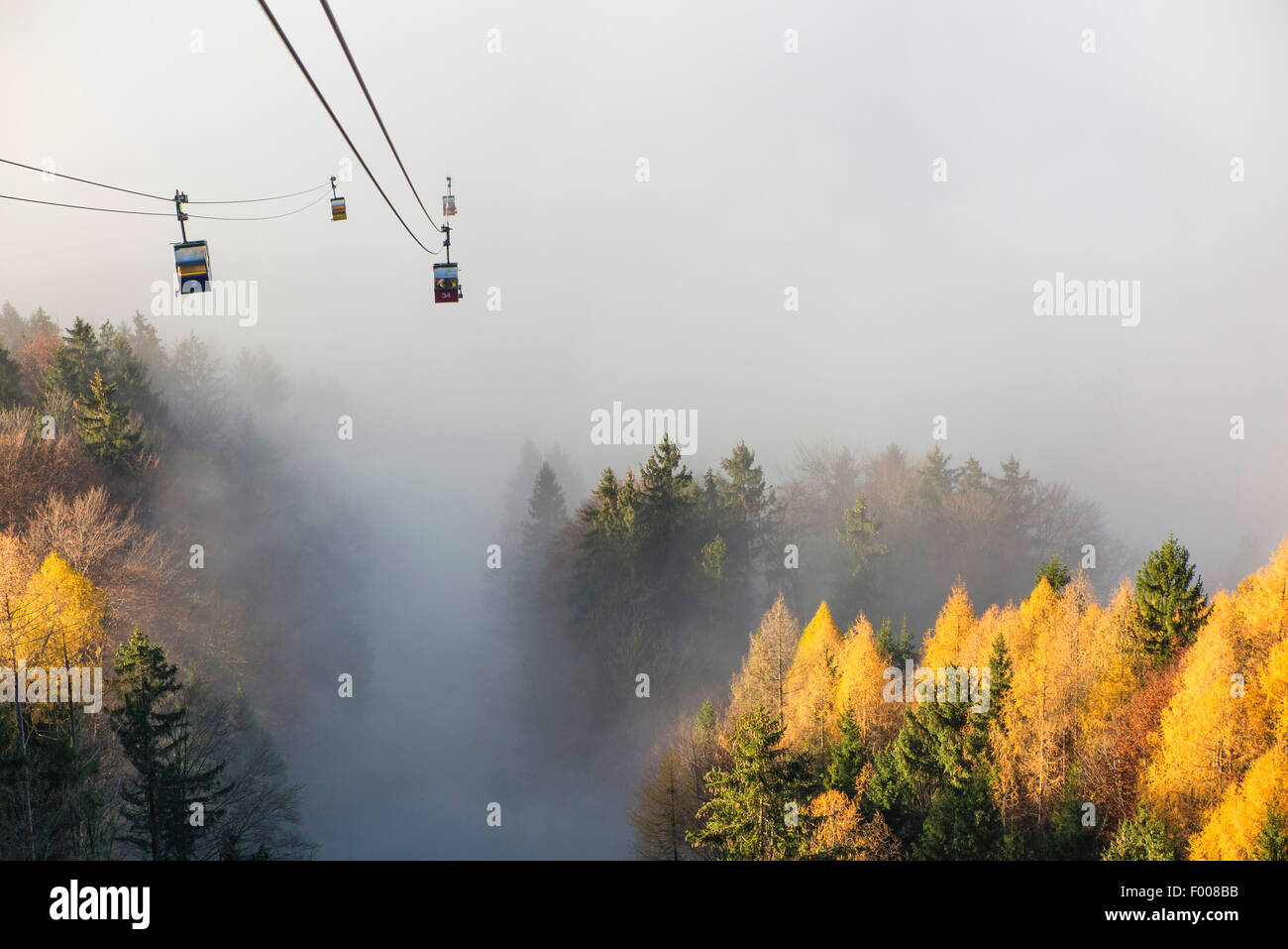 cable way comes from the sunshine on summit to the mist in the valley, Germany, Bavaria, Kampenwand, Hohenaschau Stock Photo