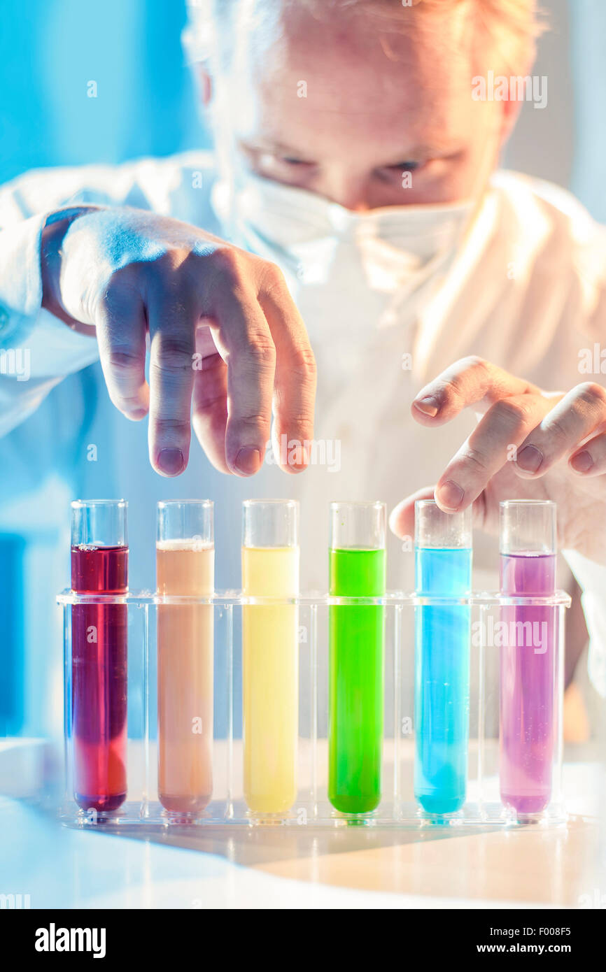 Scary Scientist Picking Different Colored Samples Stock Photo
