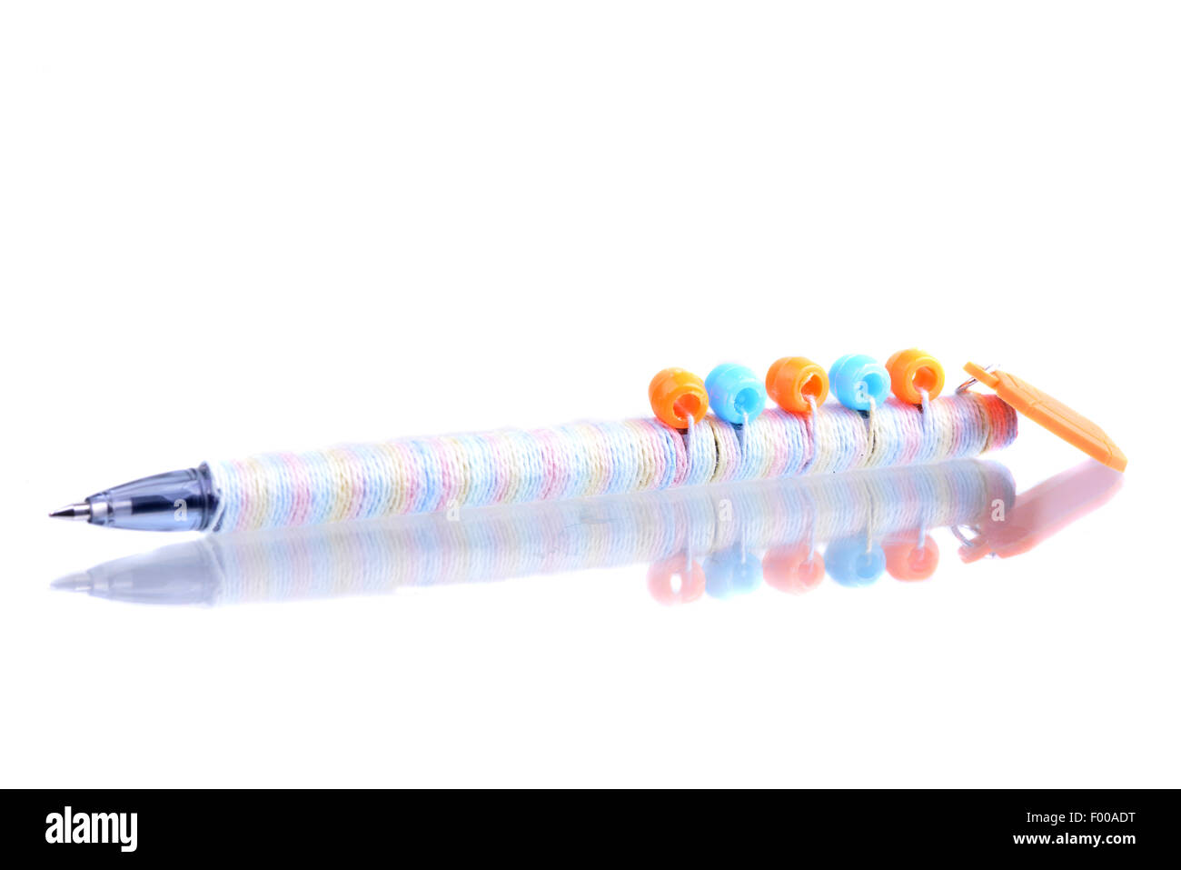 Regular pen decorated with thread and beads isolated on white with reflection Stock Photo