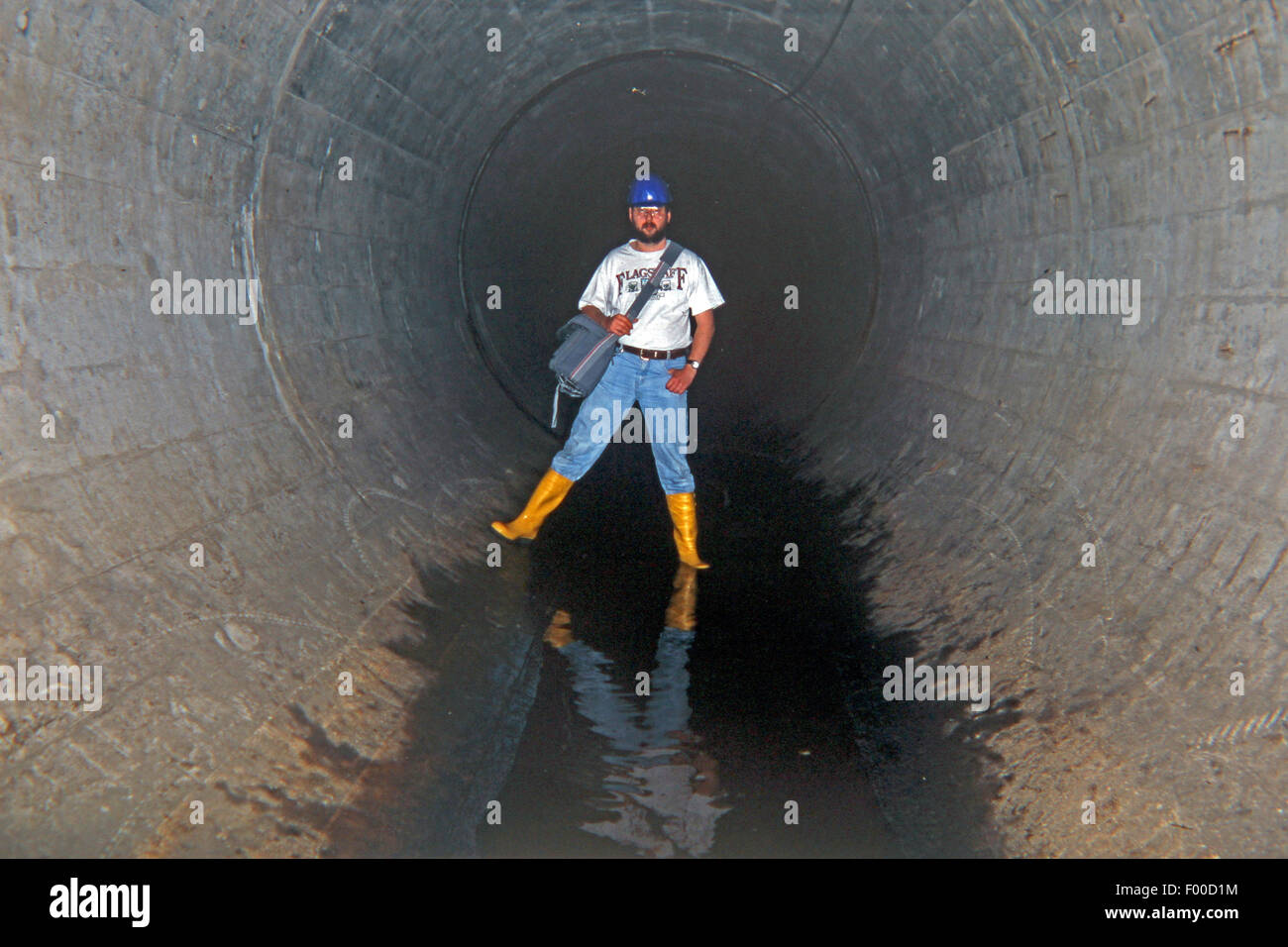 man in large wastewater pipeline, Germany Stock Photo