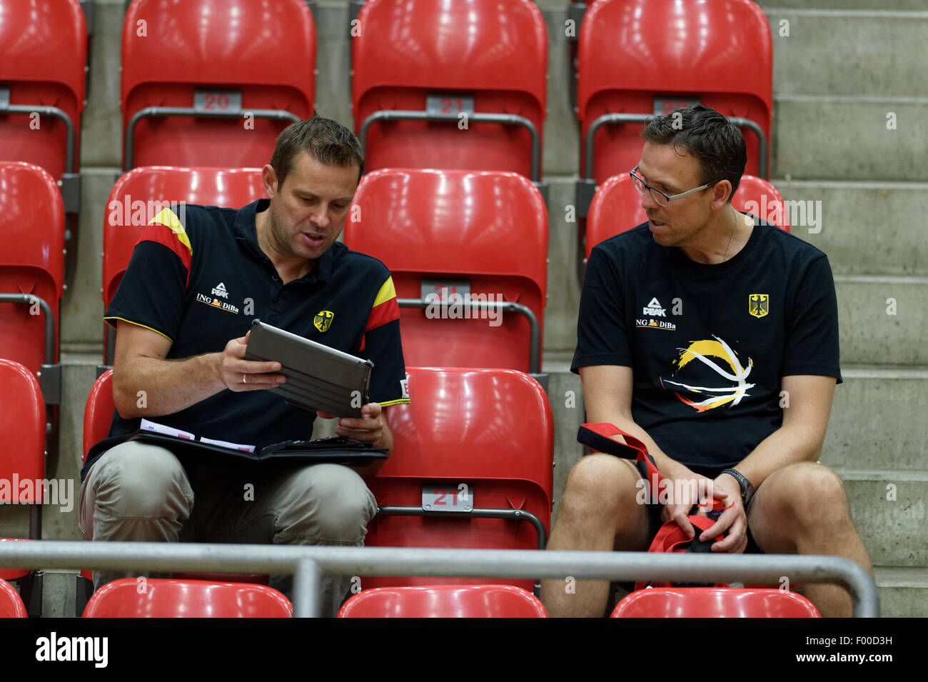 Germany's coach Chris Fleming (R) and sports director of the Deutsche  Basketball Bund DBB, the German basketball federation, sit on the stand  during the practice session of Germany's national basketball team in