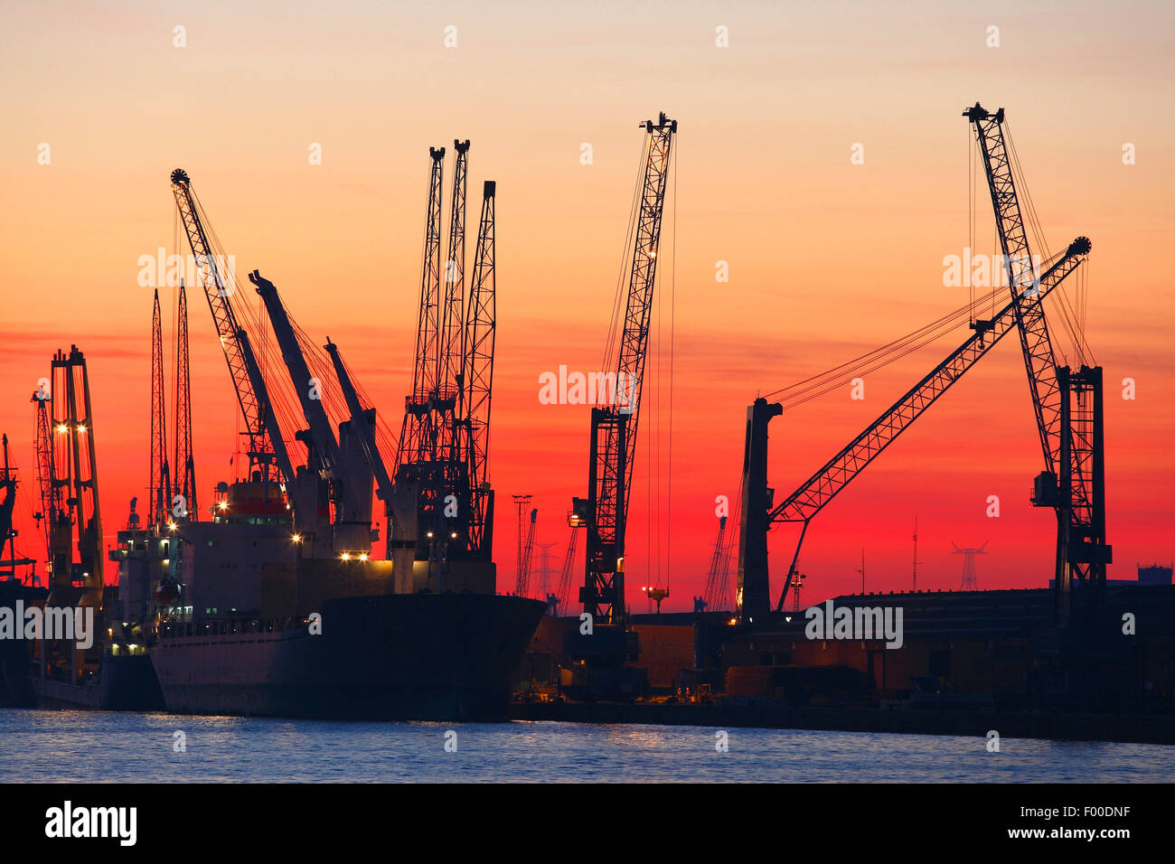 Ships in dock at oil refinery from the petrochemical industry of the Antwerp harbour at sunset, Belgium, Antwerp Stock Photo
