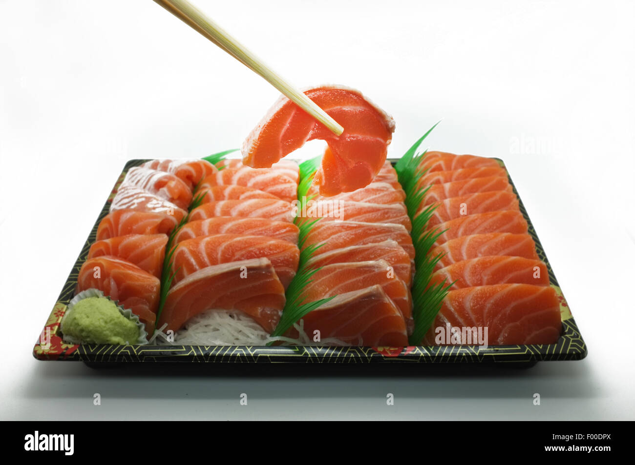 Chopsticks pinch fresh salmon sushi and wasabi Stock Photo
