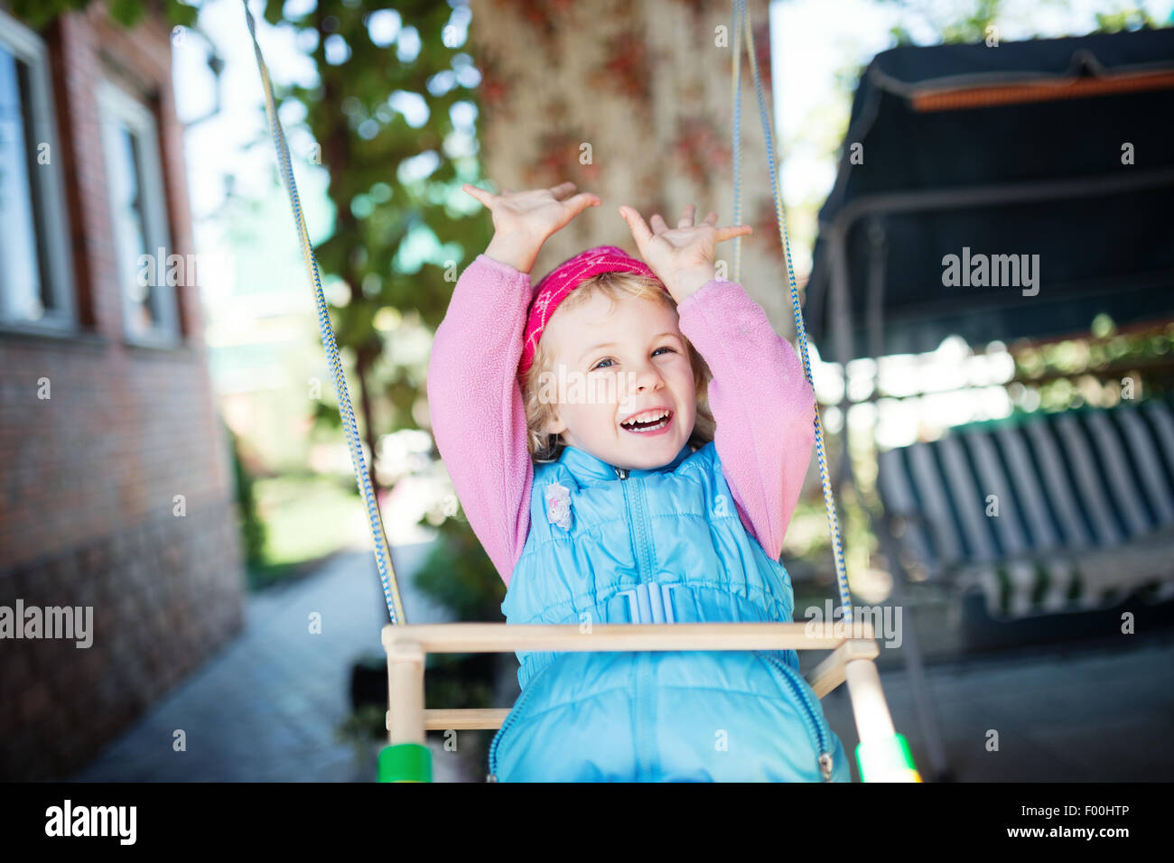 Laughing little girl on swing Stock Photo