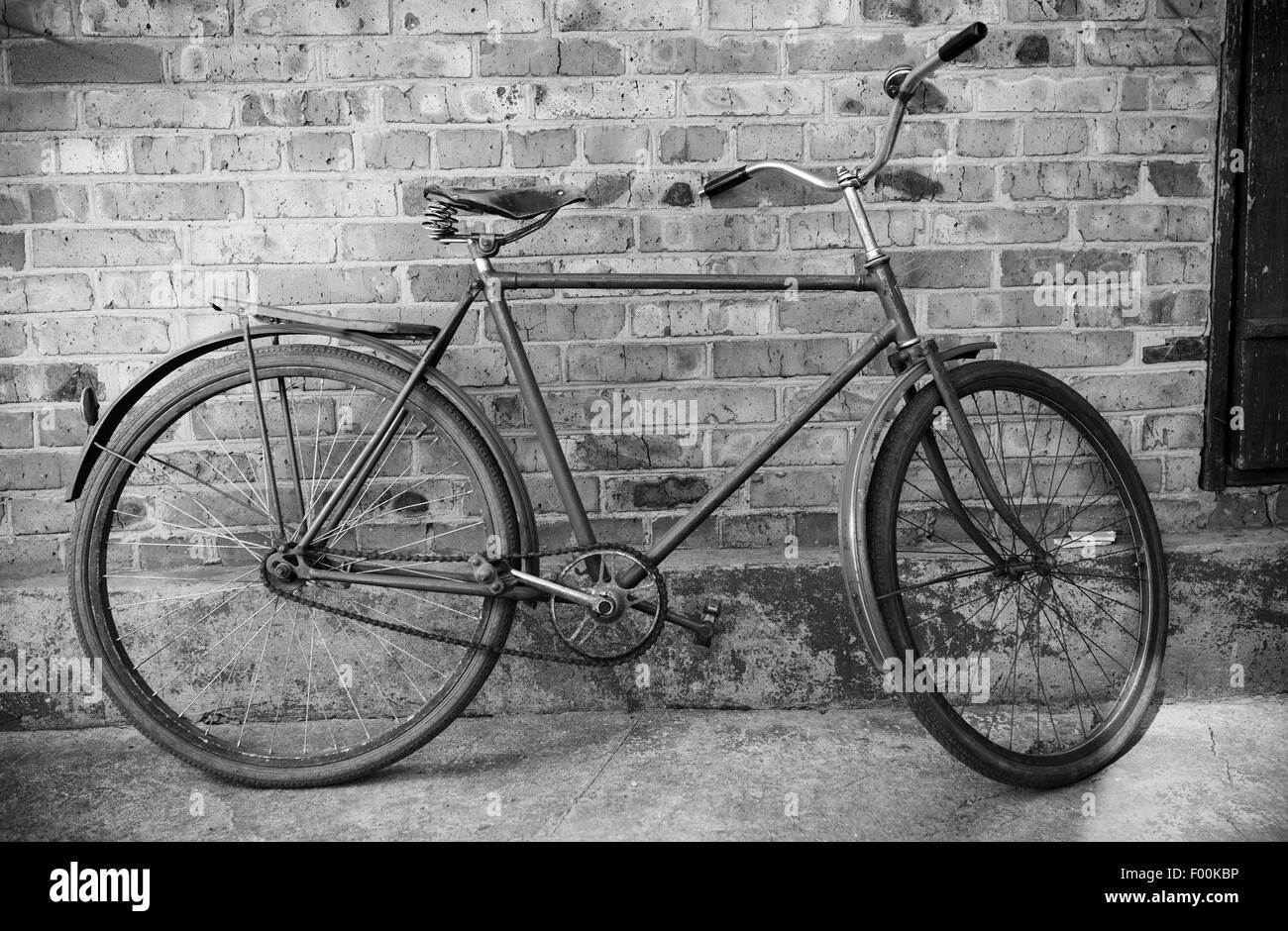 Old retro bicycle against brick wal, bw photol Stock Photo