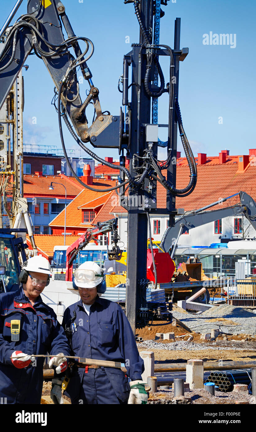construction workers and heavy machineries Stock Photo