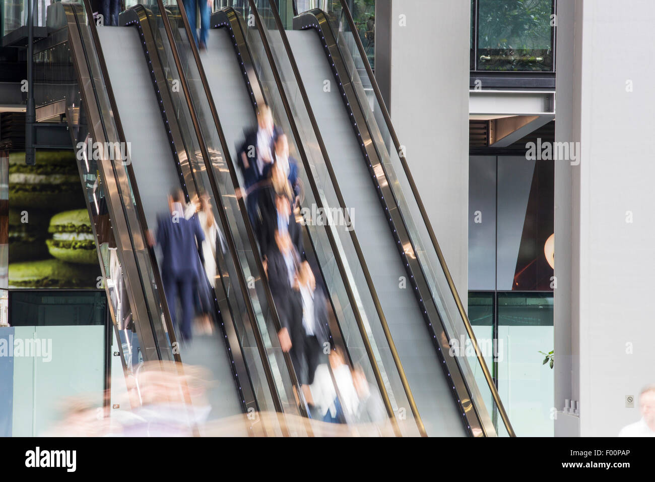 Workers entering and leaving the new Leadenhall building via escalator in the City of London, UK. Stock Photo