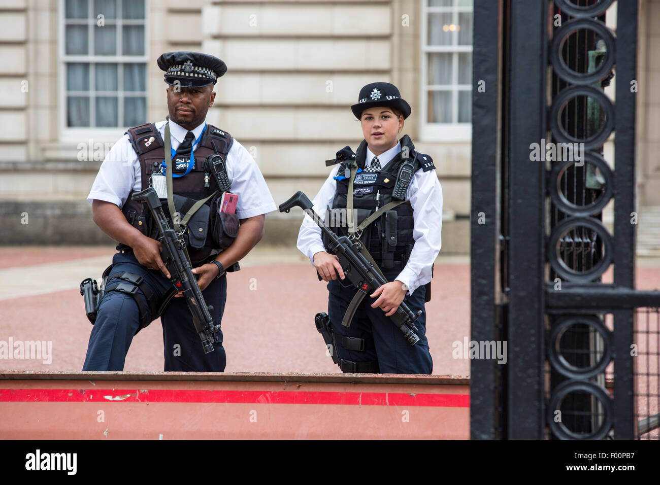 Armed police officers guarding a gateway at Buckingham Palace, London, UK. Stock Photo