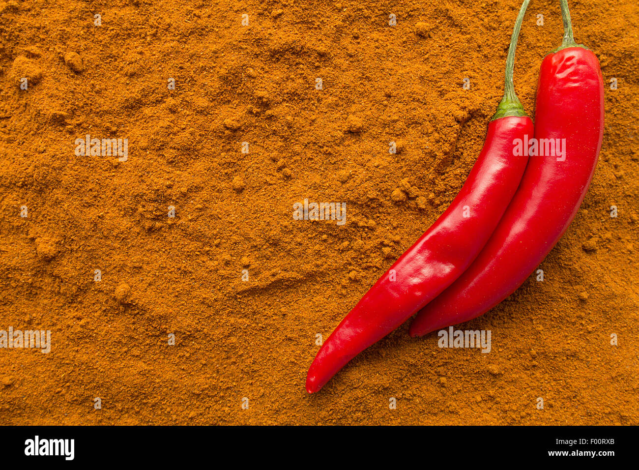 Chili pepper pods on chili powder top view selective focus Stock Photo
