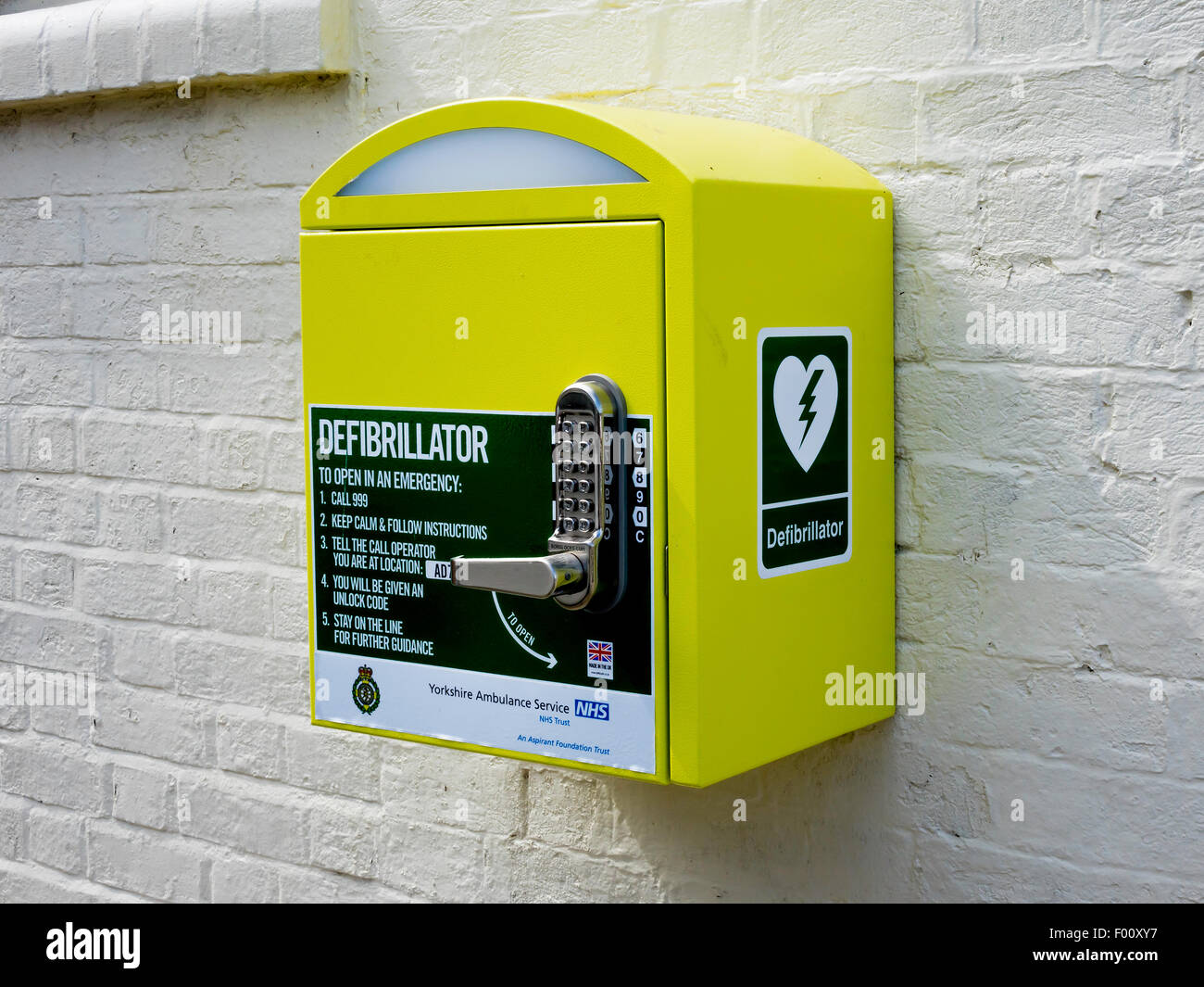 Heart defibrillator life saving equipment for cardiac arrest with code lock for public use in a village in  England UK Stock Photo