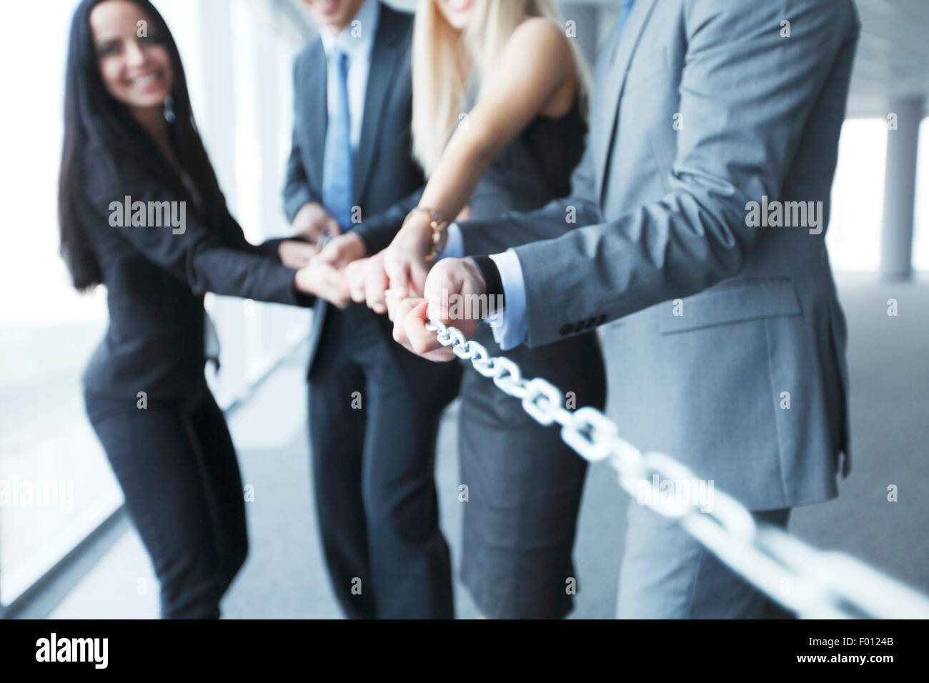 Businessmen pulling chain Stock Photo Alamy