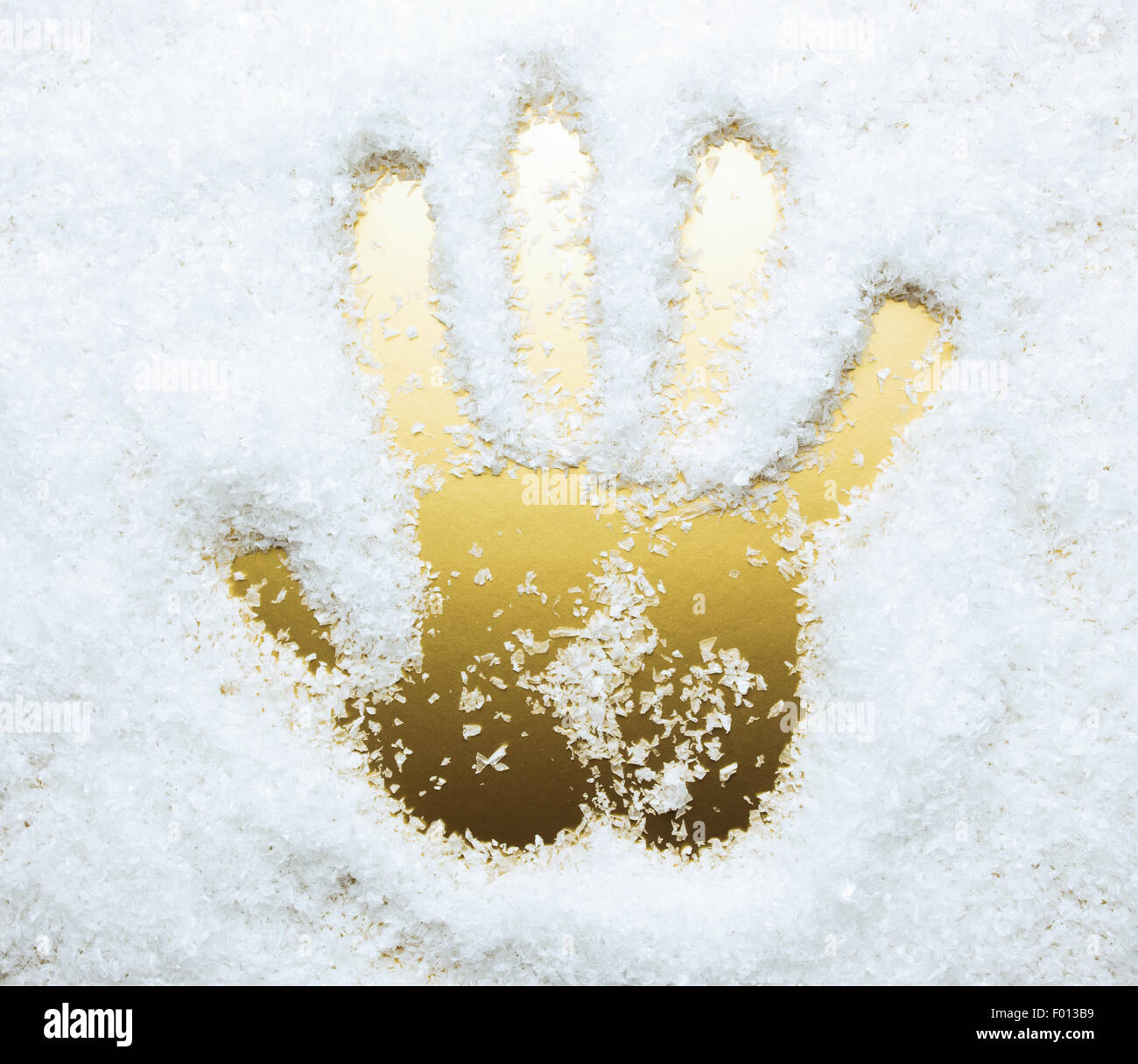 Hand print in artificial snow, golden color Stock Photo