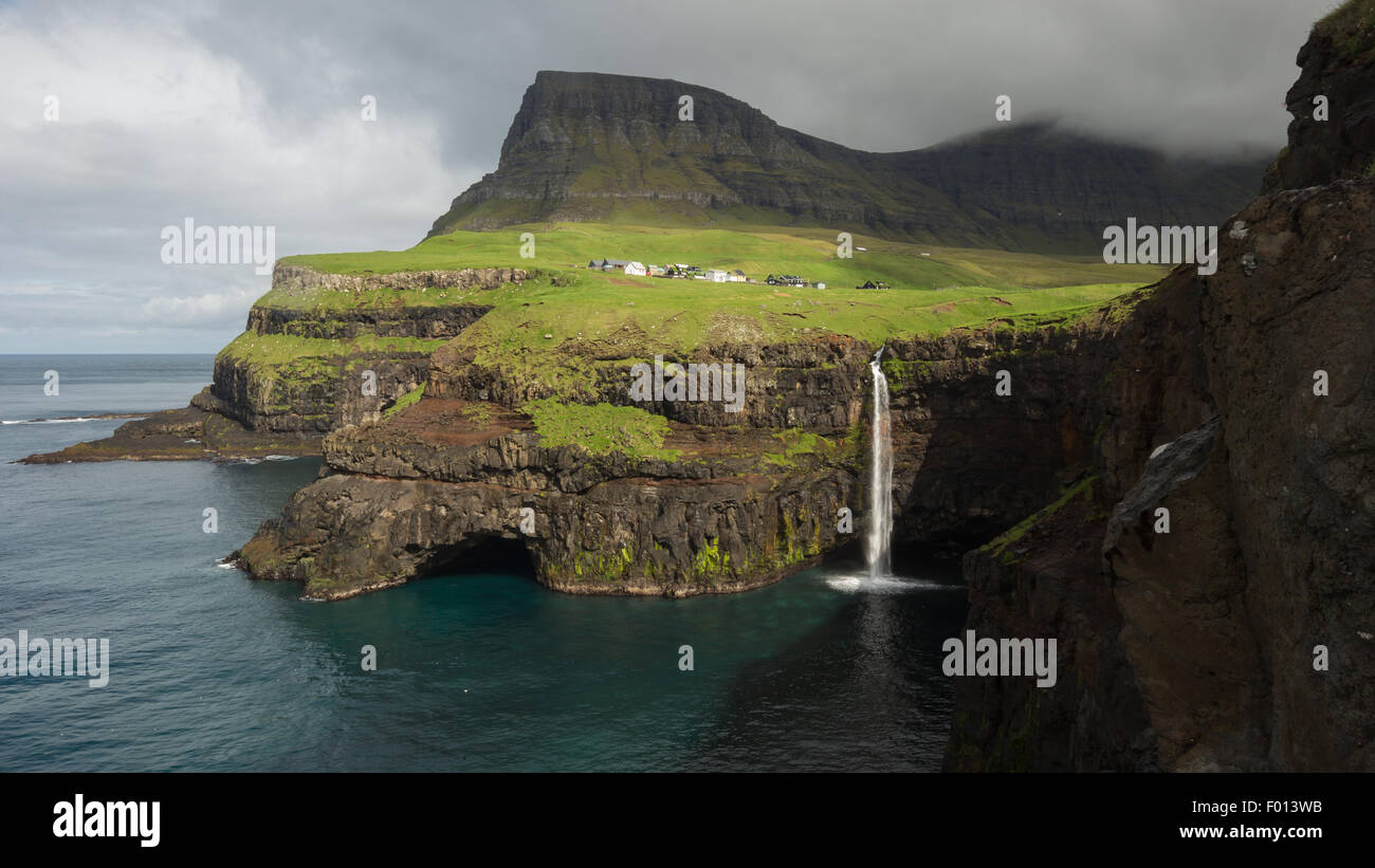 The Mulafossur waterfall and the village of Gasadalur. Vagar Island. Faroe Islands Stock Photo
